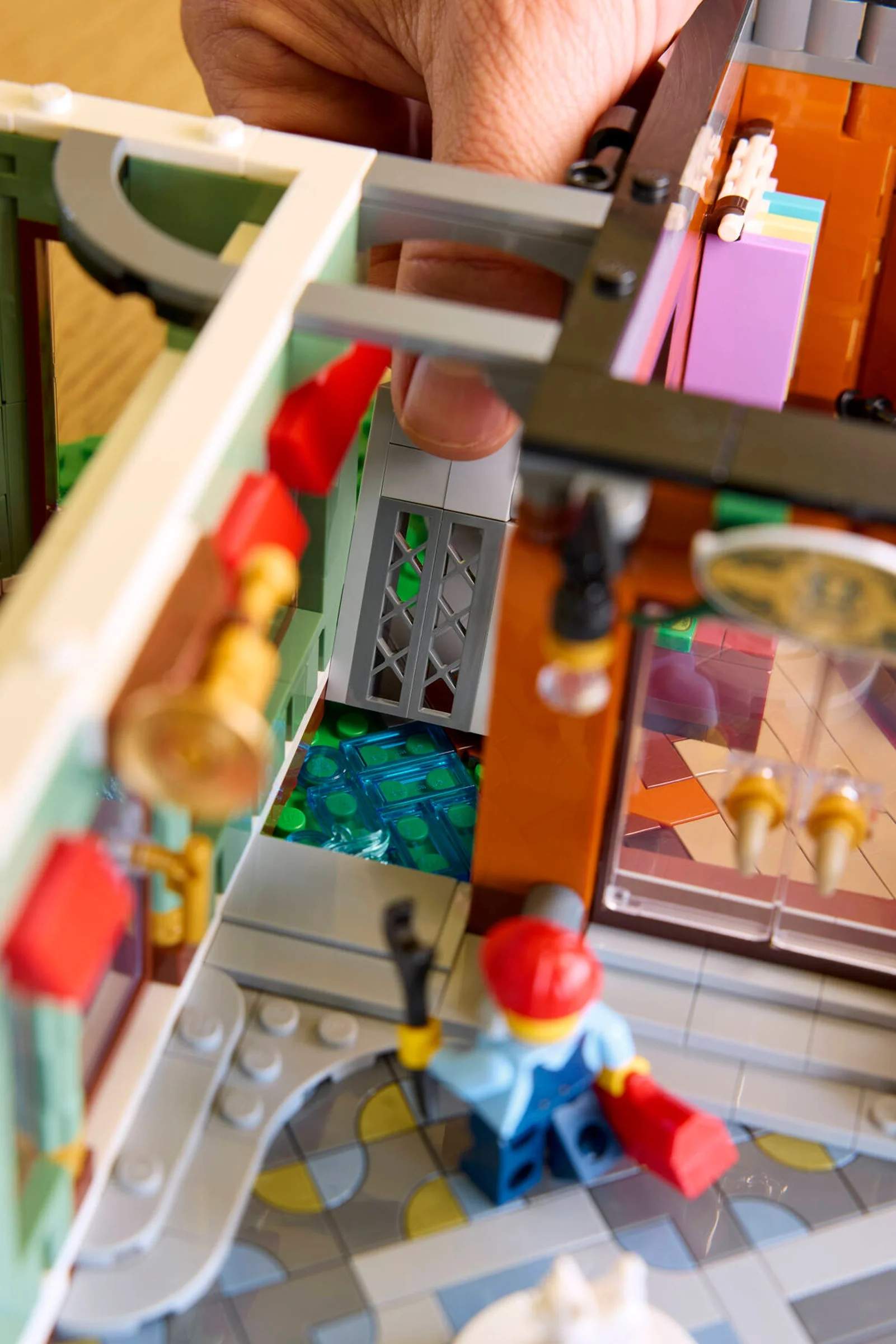 Detalii din setul LEGO 11371 Străzile Comerciale, cu o minifigurină și interioarele clădirilor.