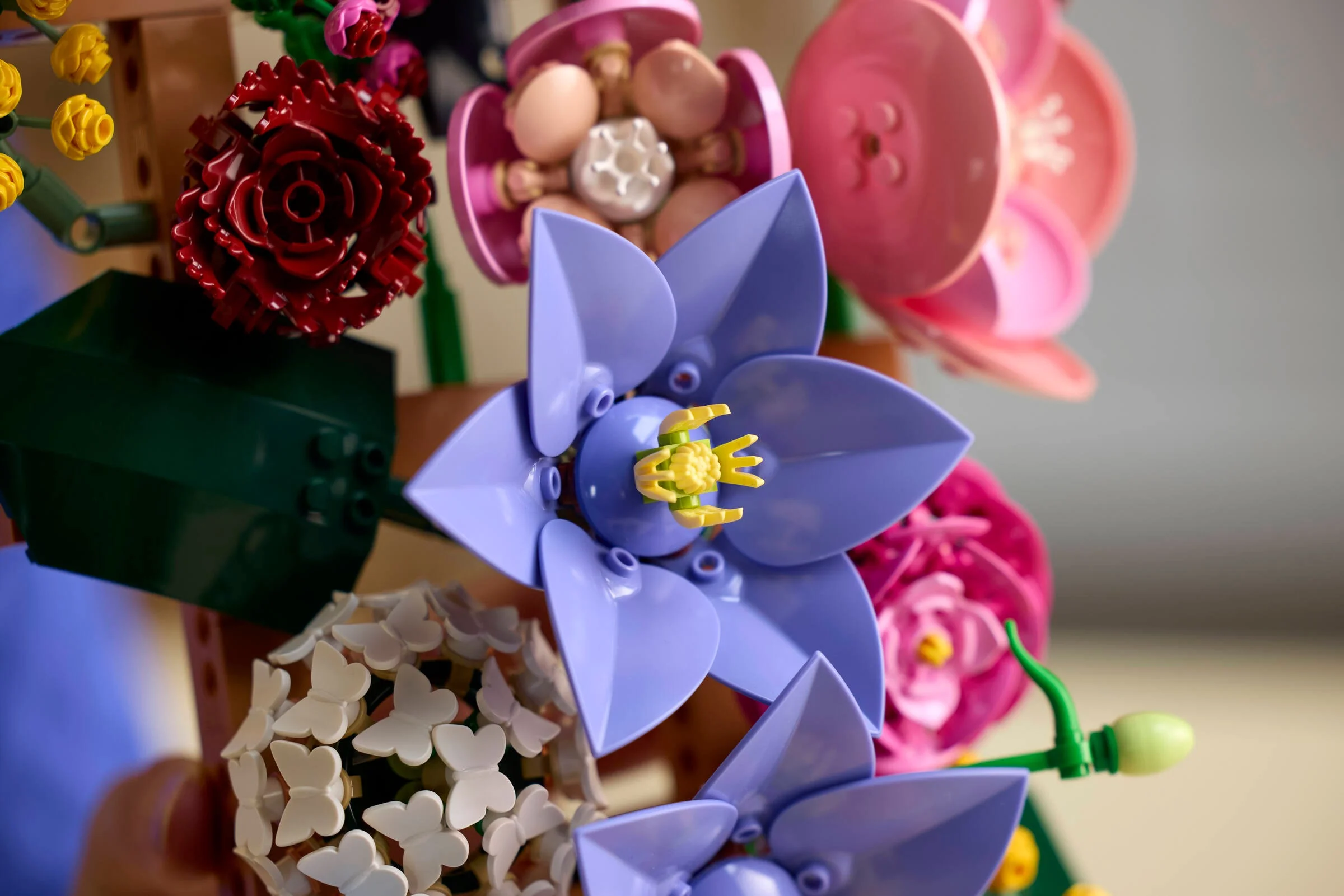 Prim plan al unui aranjament floral LEGO, cu flori multicolore detaliate.