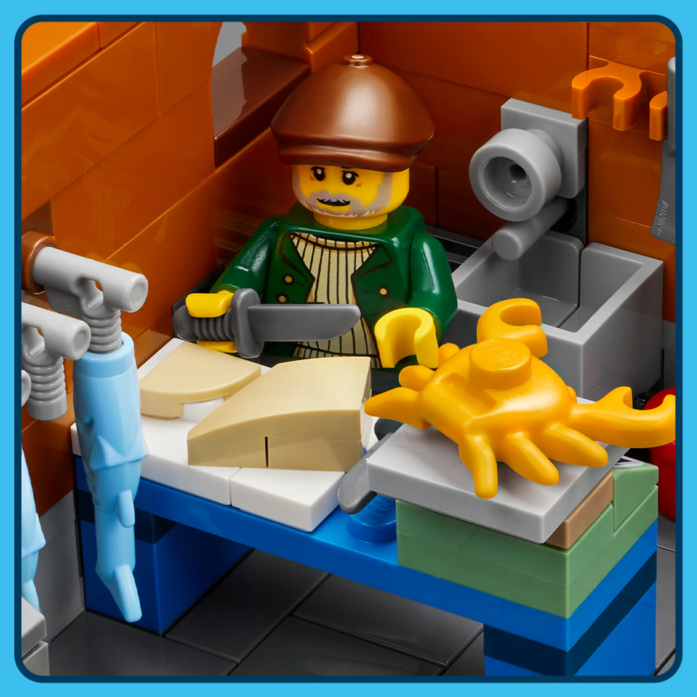 Prim-plan cu minifigurina bucătarului tăind brânză, setul LEGO 21359. Detaliu.