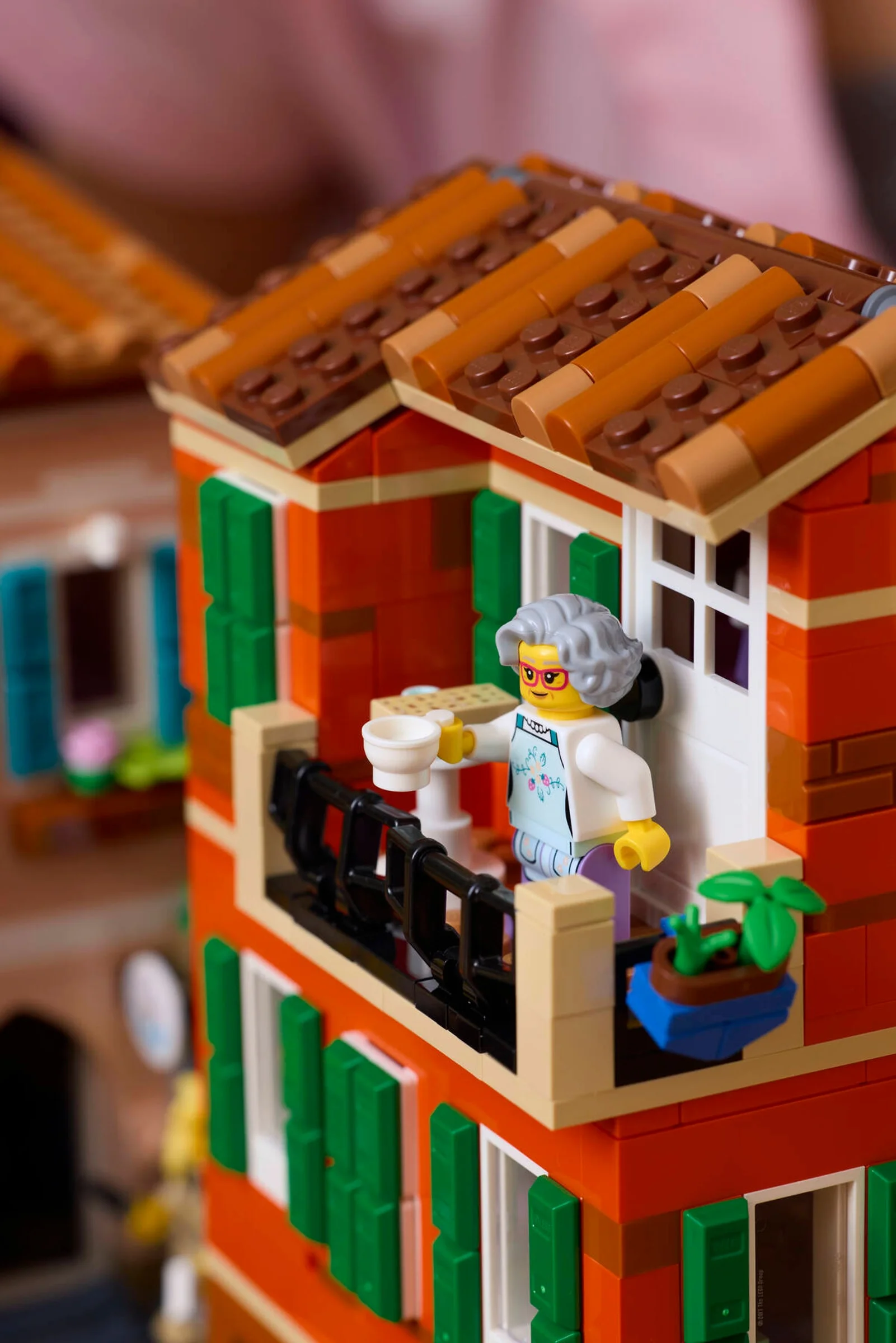 Prim-plan cu o minifigurină bunică pe balconul unei case din Riviera Italiană LEGO.