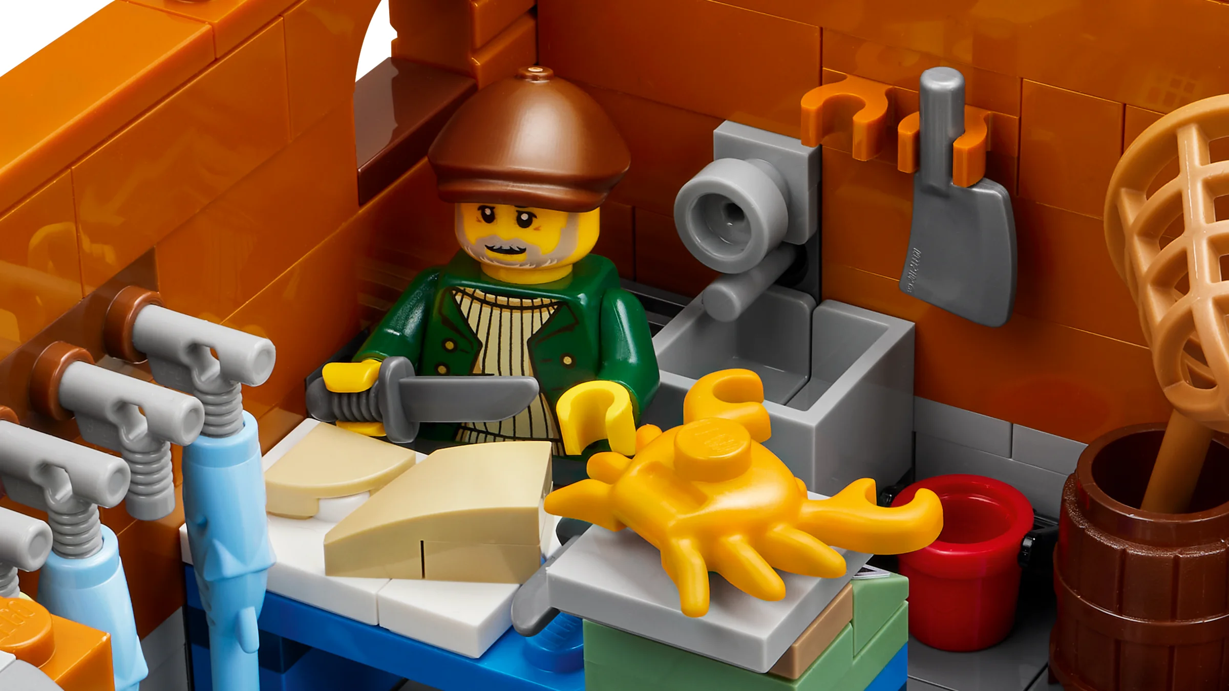 Prim-plan cu un pescar LEGO, lucrând cu o crabă galbenă într-o bucătărie detaliată.