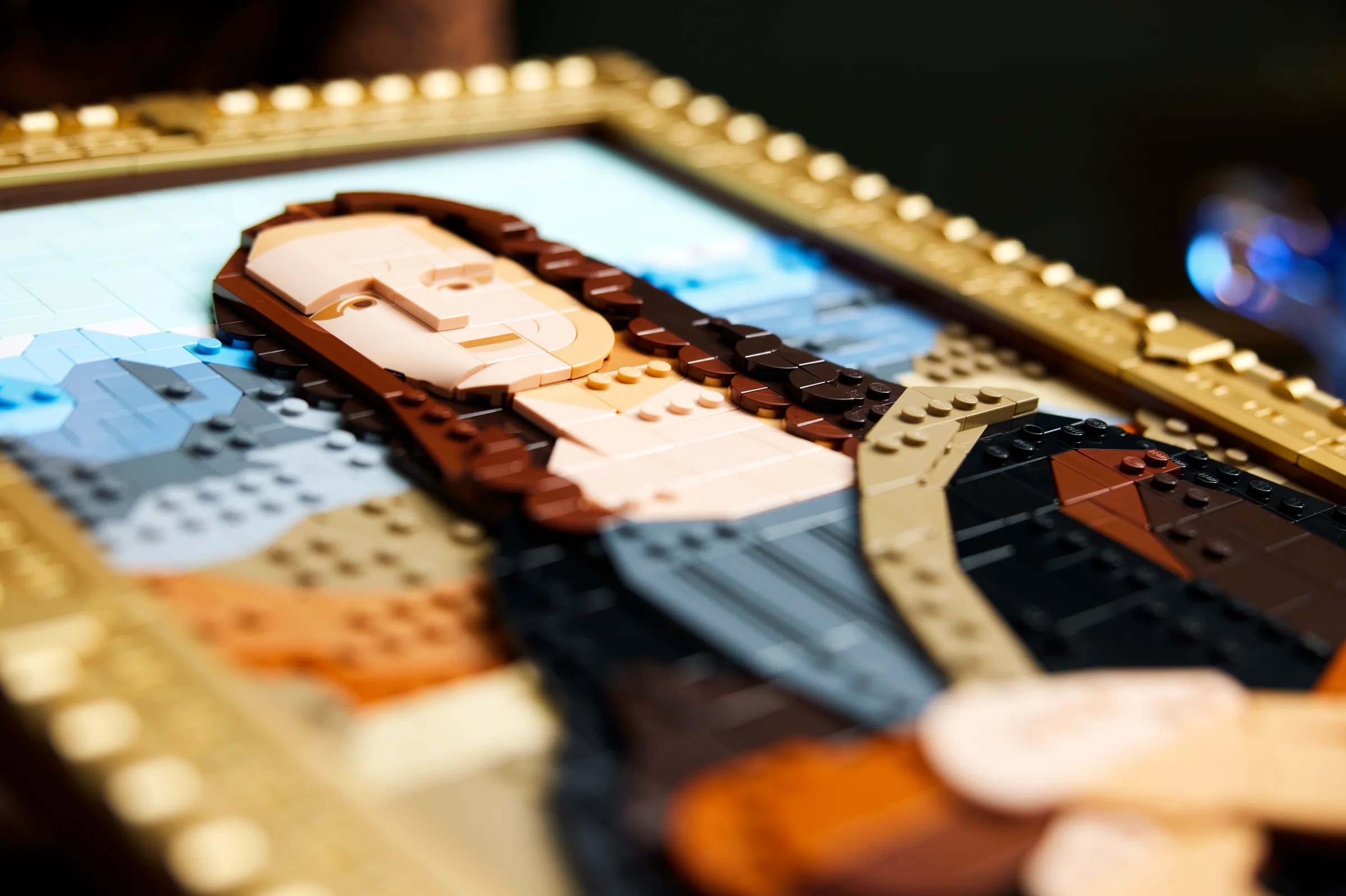 Prim-plan al modelului LEGO Mona Lisa, cu rama aurie detaliată. O replică artistică.