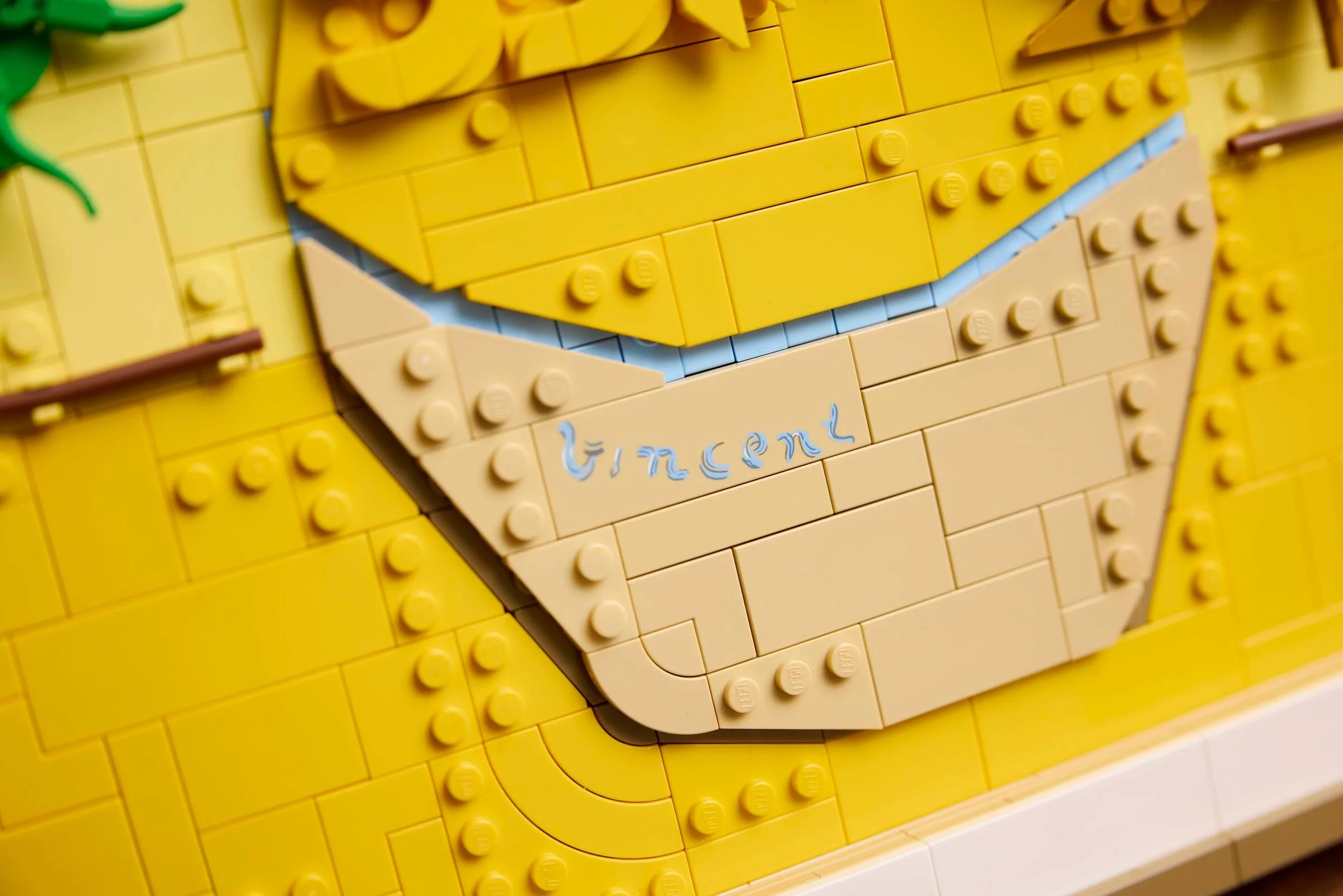 Prim-plan detaliat cu semnătura 'Vincent' pe modelul LEGO Sunflowers. Detalii fine ale construcției.
