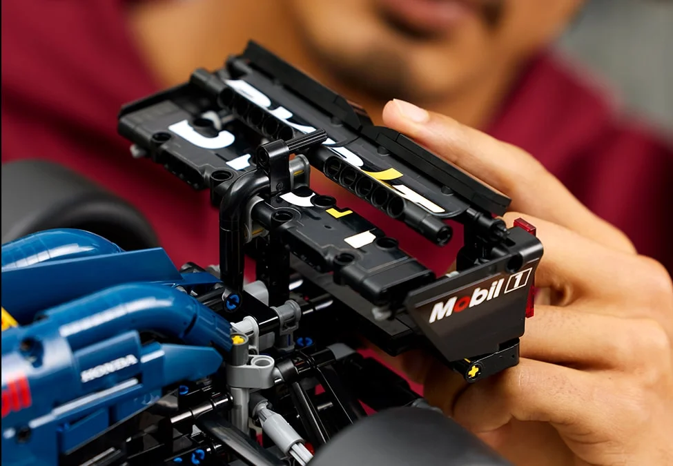 Construirea aripii față a modelului LEGO Red Bull Racing RB20. Detalii fine și logo-uri.