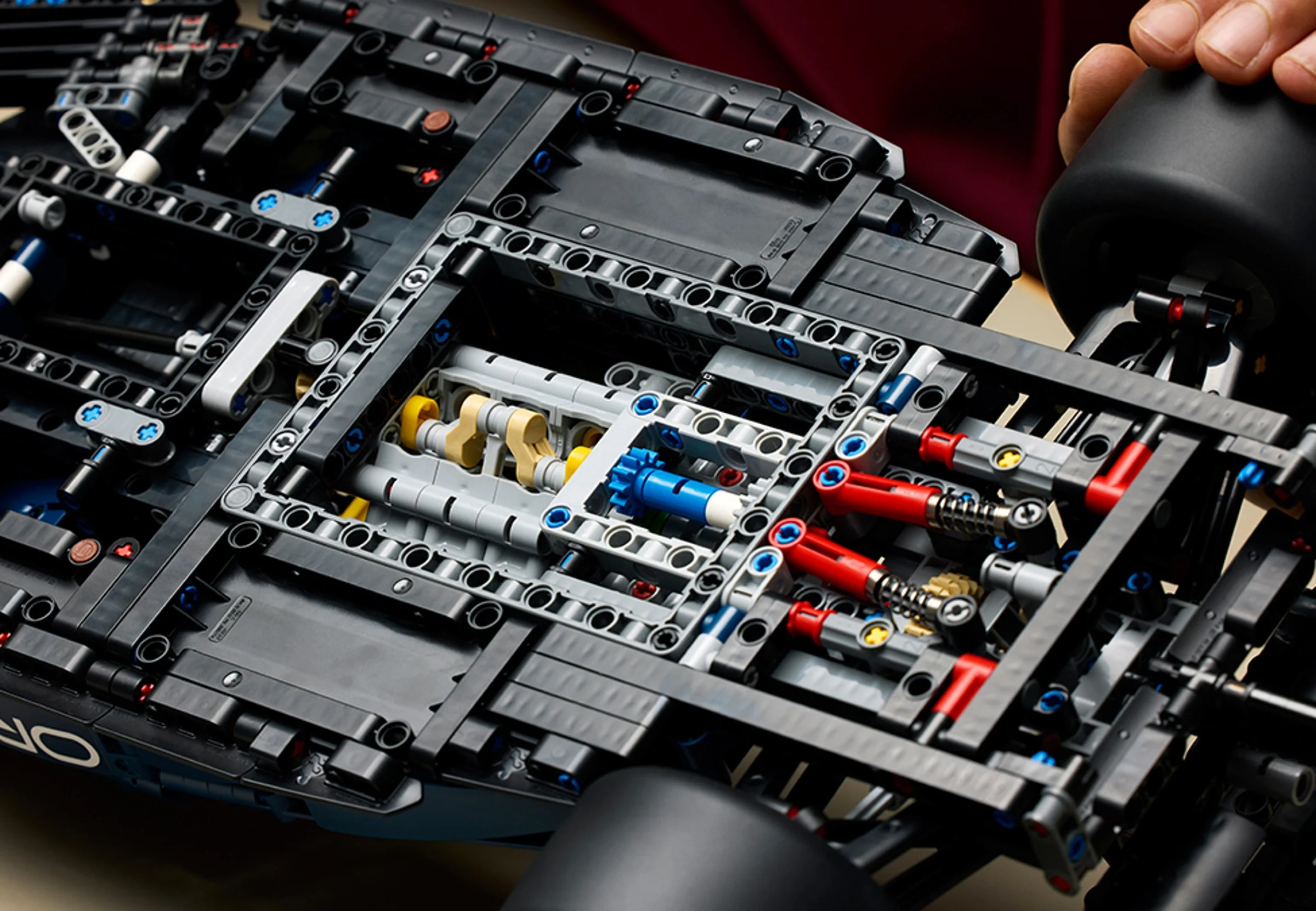 Detalii ale mecanismelor interne ale mașinii de curse Red Bull RB20, asamblată din piese LEGO Technic.
