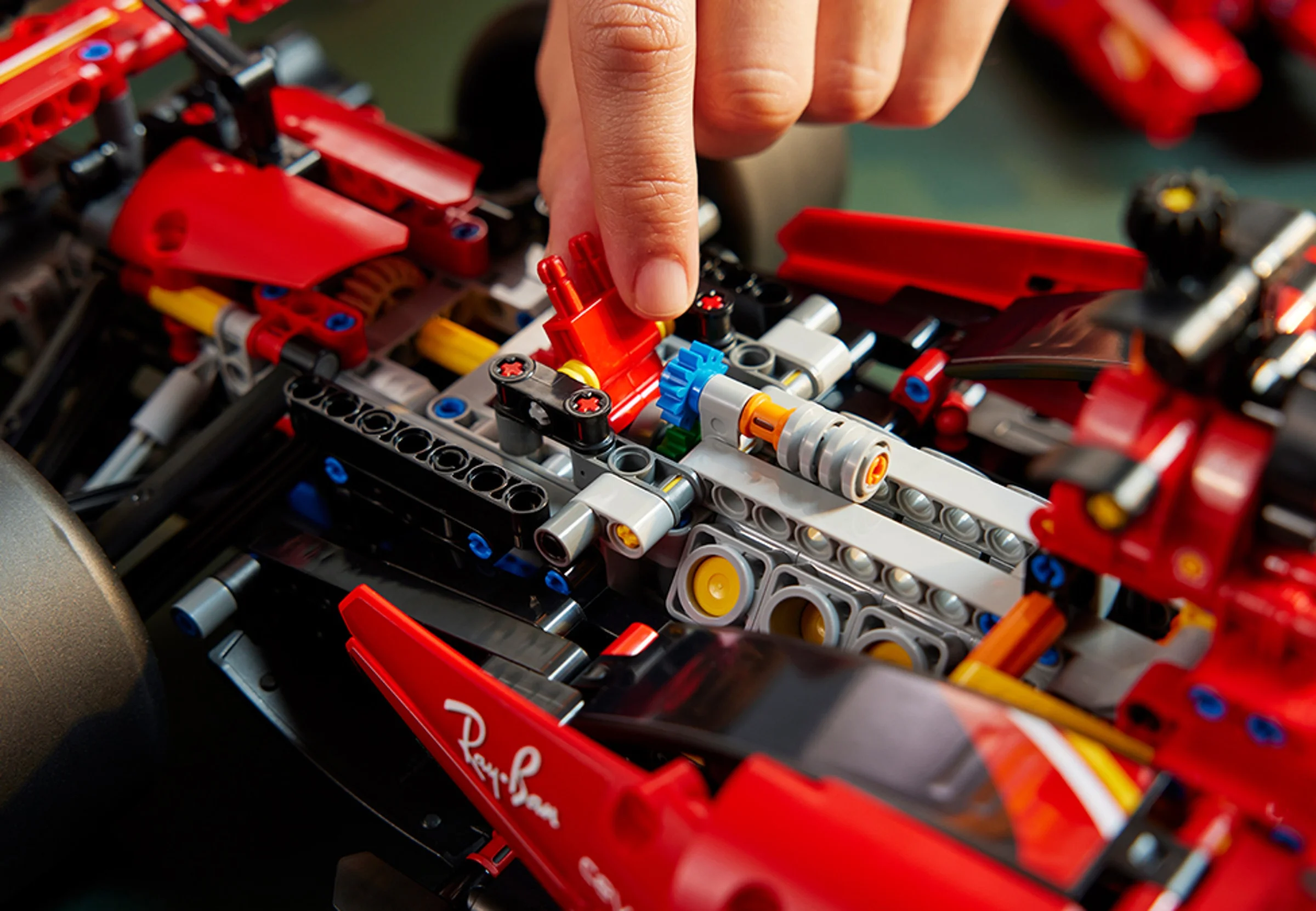 Construirea modelului Ferrari SF-24 F1. Detaliu cu mâna asamblând părți componente.