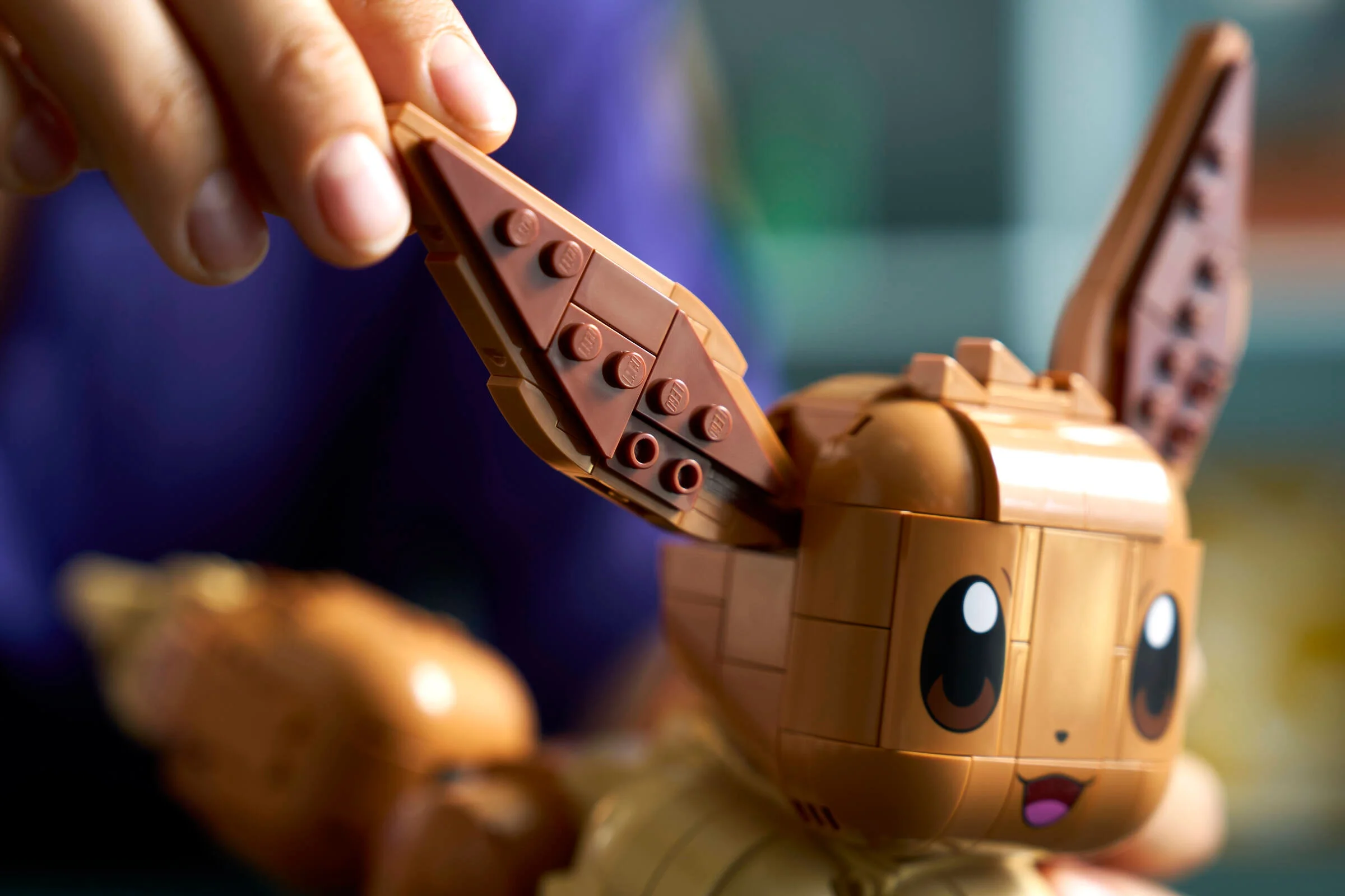 Eevee LEGO cu o ureche detașată, detalii de construcție vizibile. Imagine detaliată a setului.