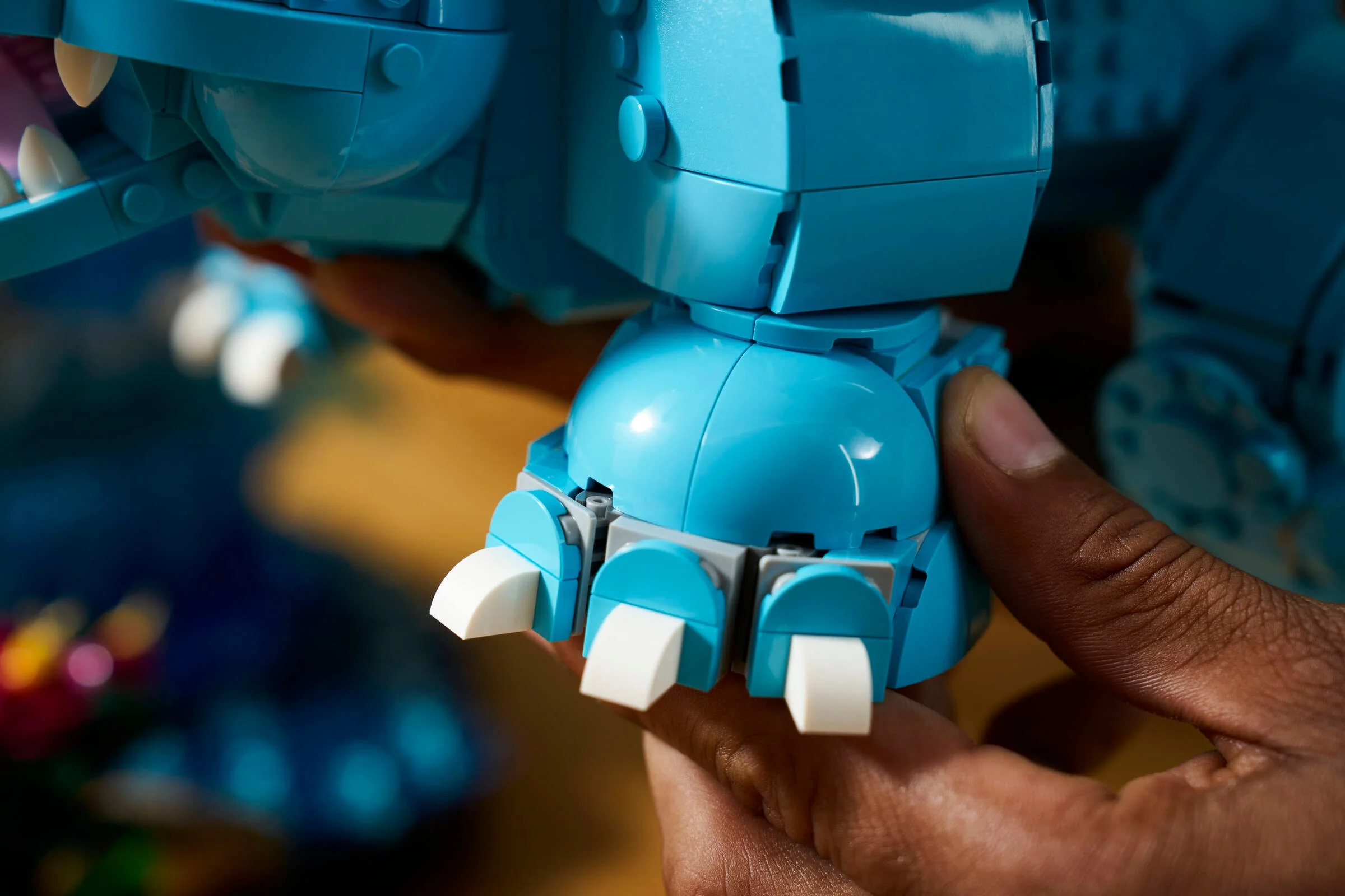 Detalii ale construcției Blastoise LEGO. Se văd picioarele și o mână care ține modelul.