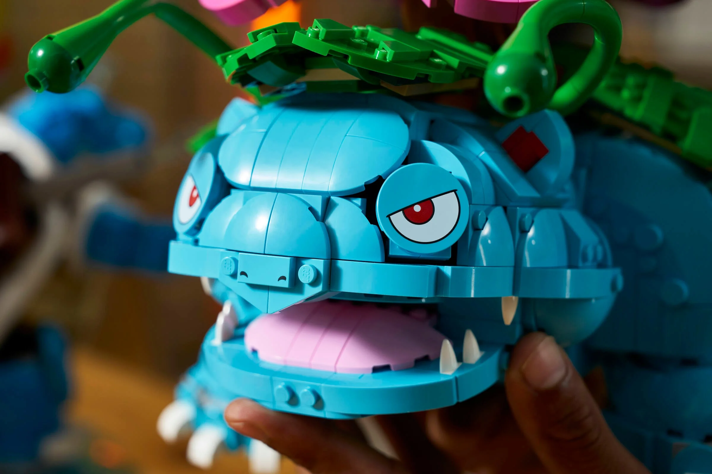 Prim-plan cu Venusaur construit din LEGO, detaliind capul și floarea de pe spate.