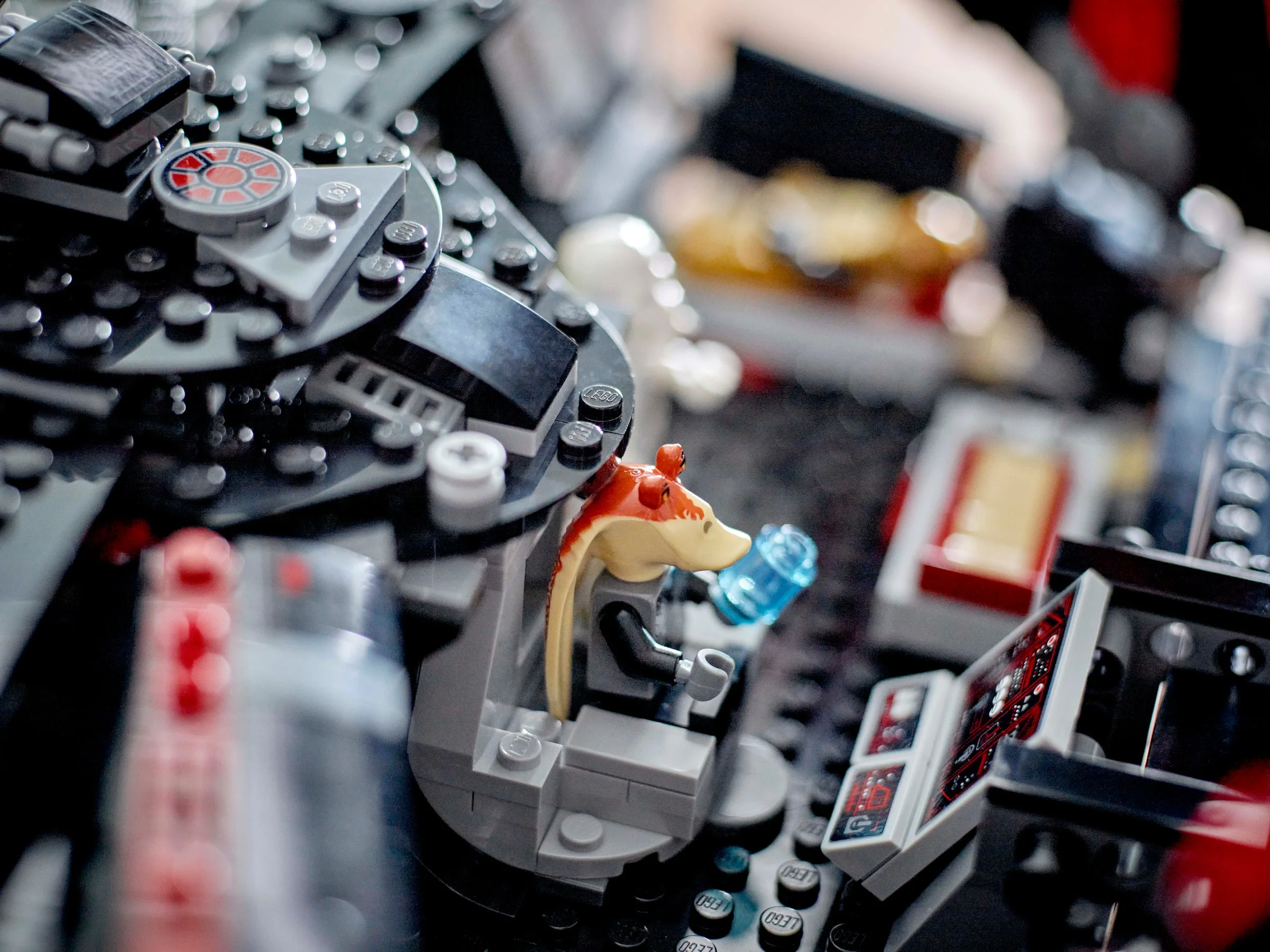 Prim-plan cu o minifigurină Jar Jar Binks în cockpit-ul Dark Falcon.