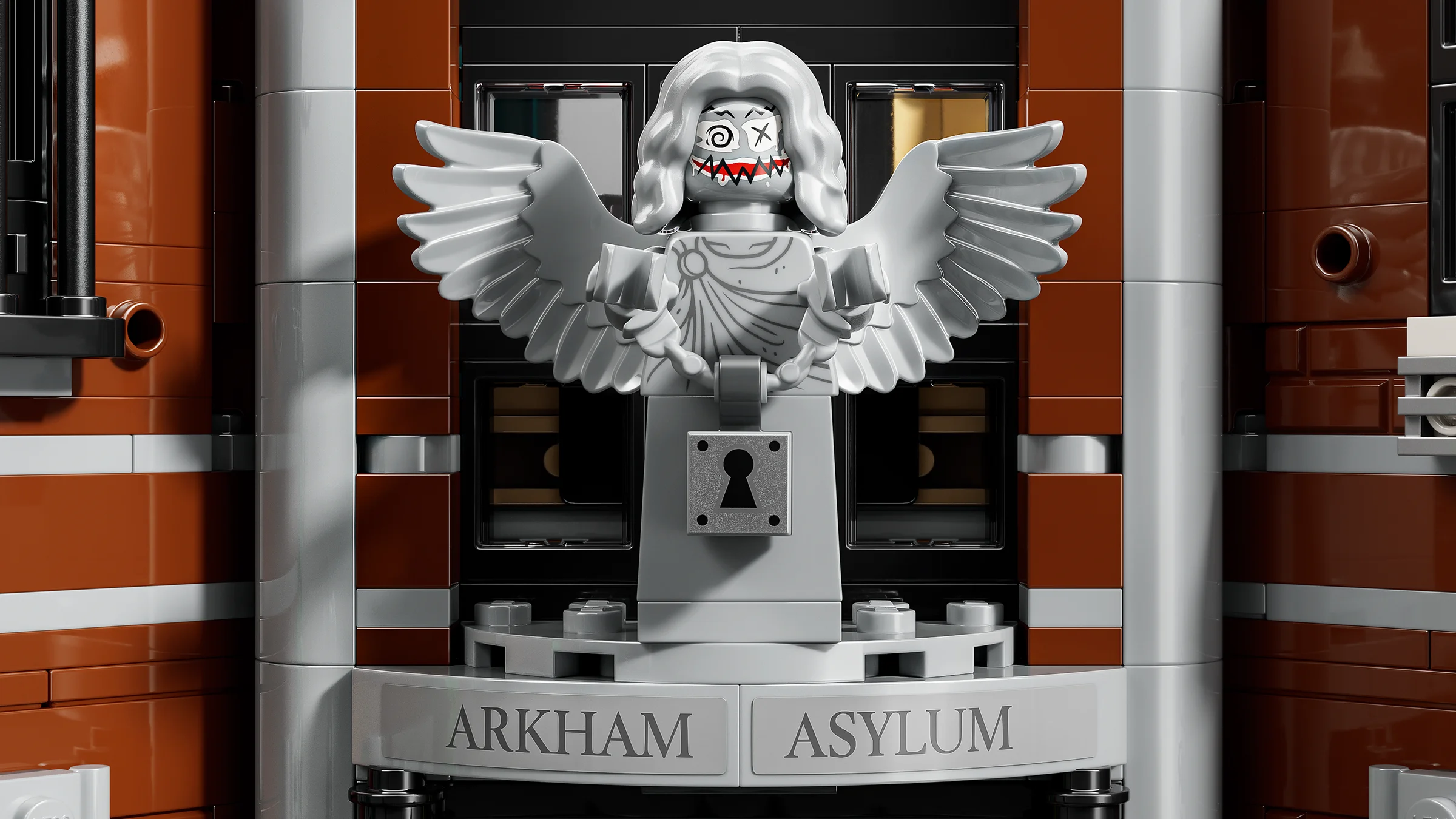 O statuie macabră, cu aripi și chip desenat, veghează intrarea în Arkham Asylum. Detaliu captivant!
