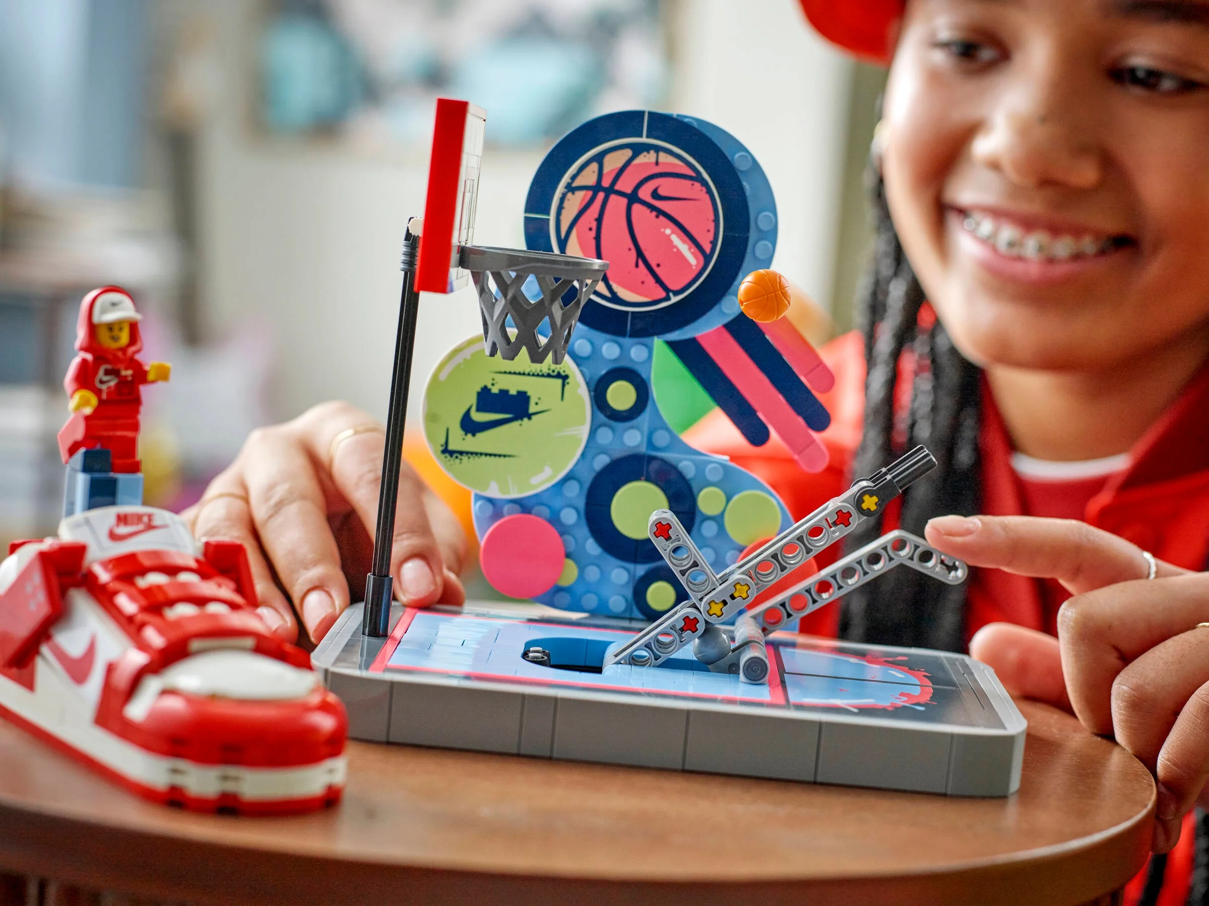 Prim plan cu modelul LEGO Nike Dunk Trickshot și o persoană interacționând cu mecanismul.