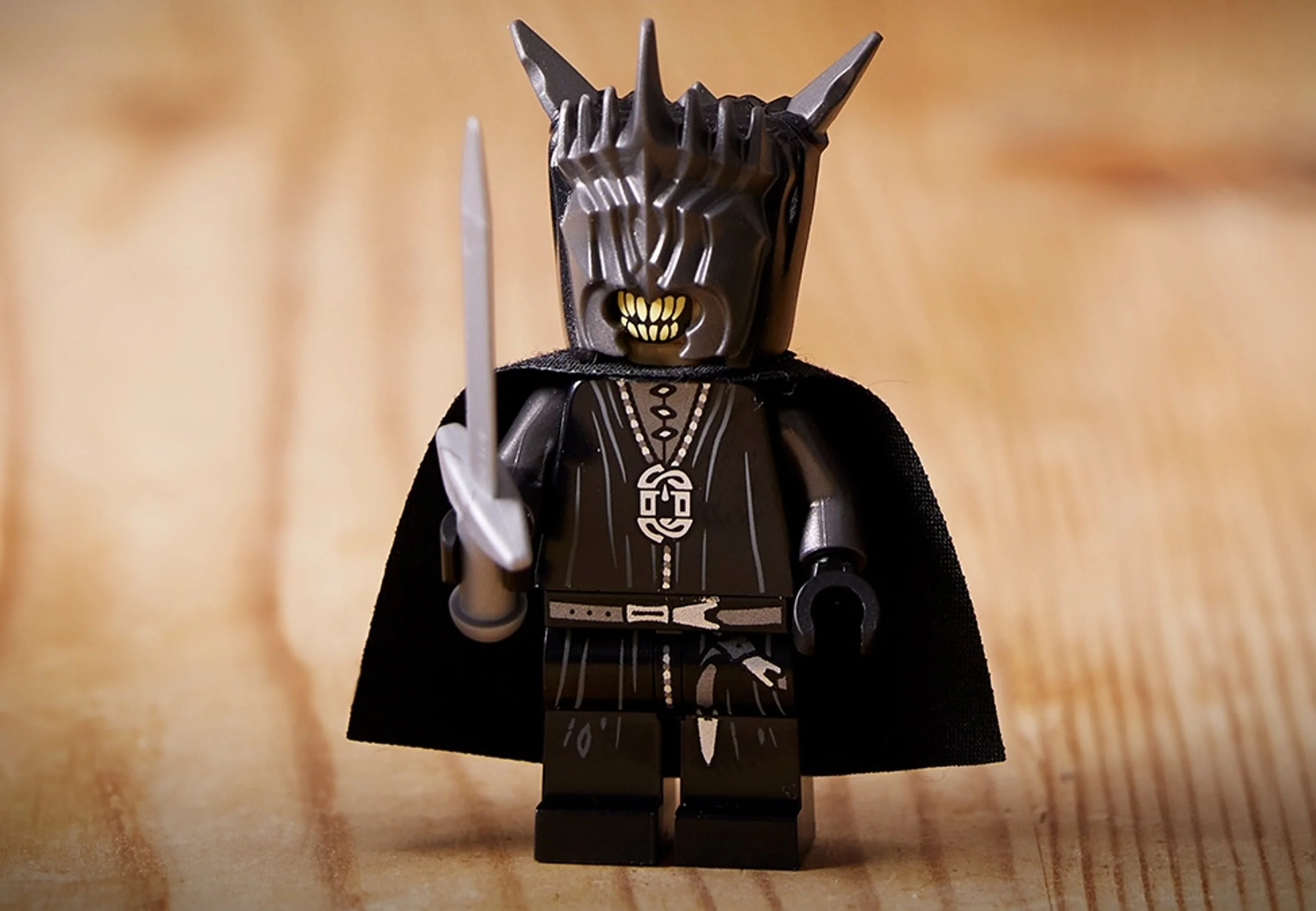Minifigurina Sauron detaliată cu armură, cap cu coroană și sabie.