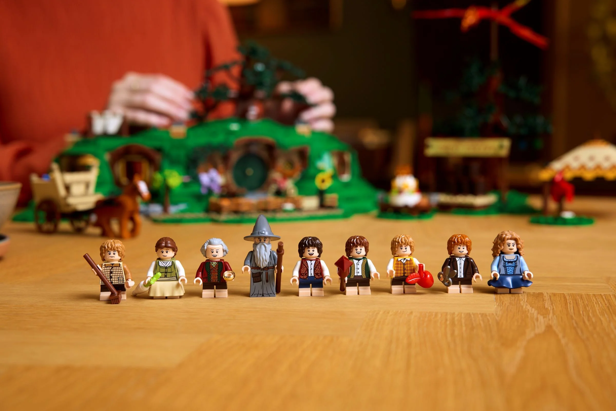 Minifigurinele din setul LEGO The Shire, inclusiv Bilbo, Frodo, Gandalf, și alți hobbiți.