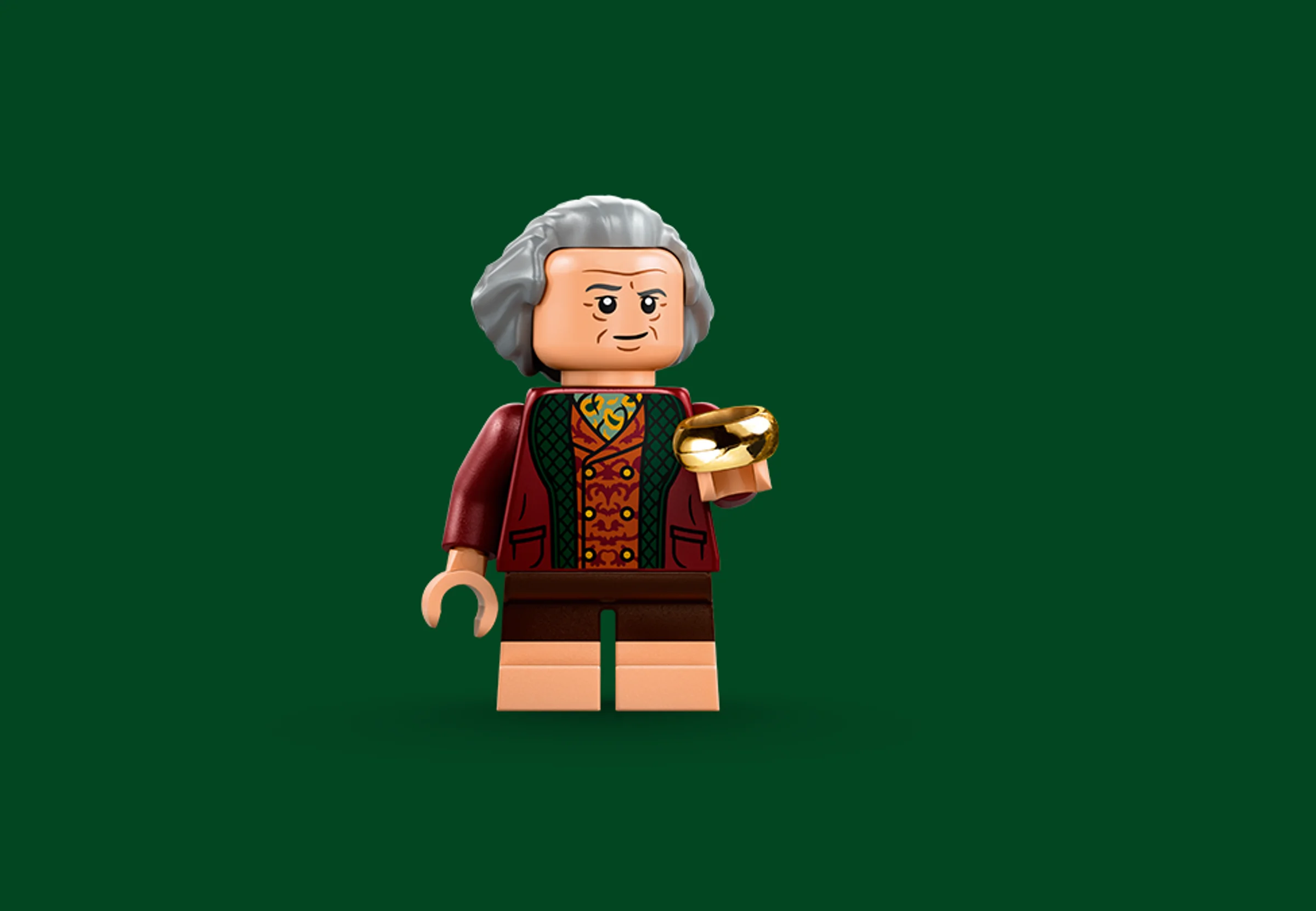 Prim-plan cu minifigurina LEGO Bilbo Baggins, ținând inelul. Detalii precise și culori vii.