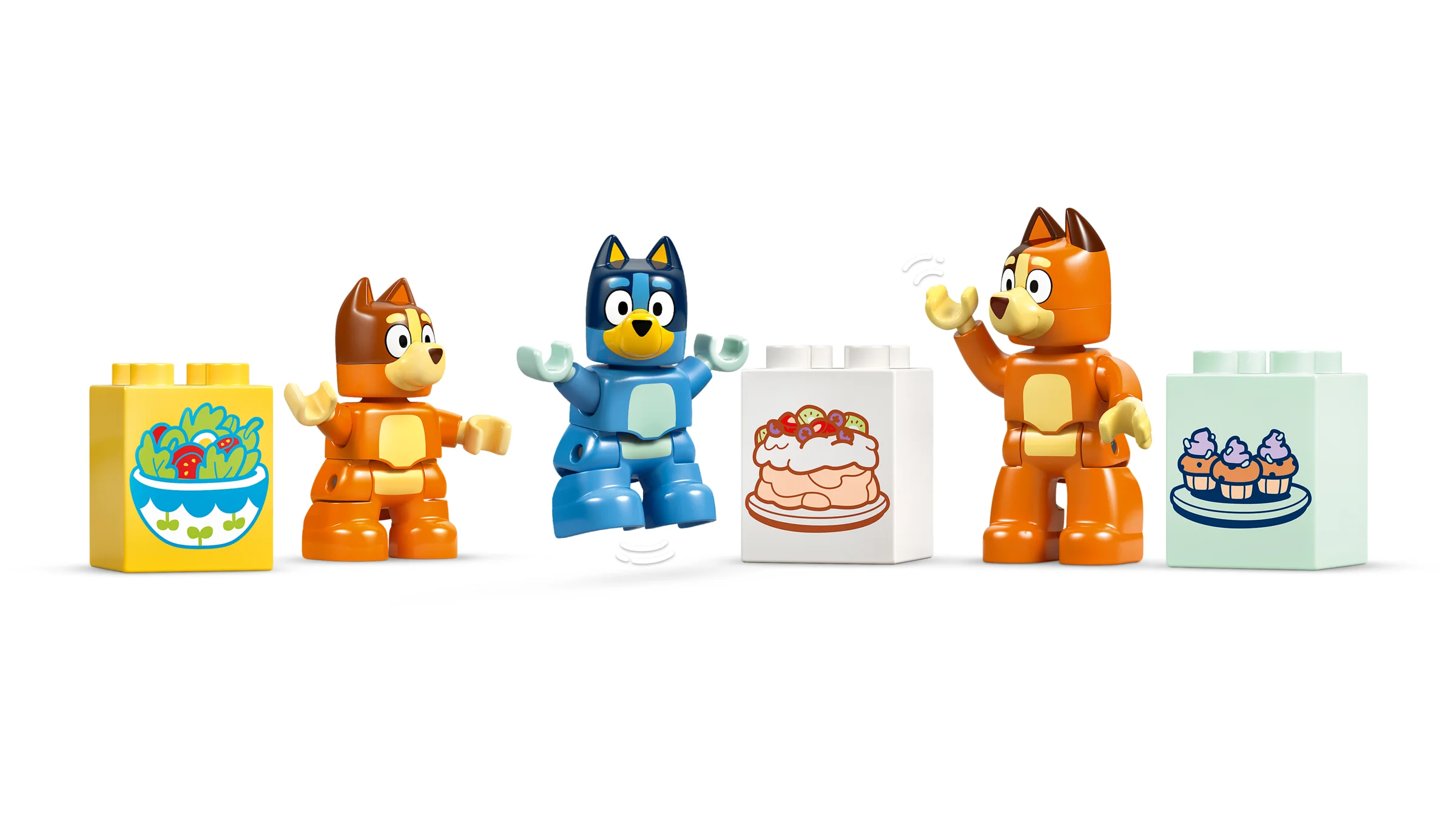 Personaje Bluey și Bingo Duplo cu cuburi decorate cu salată, tort și brioșe.