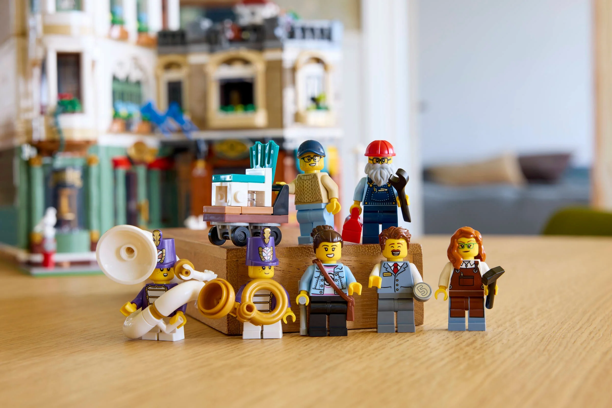 Imagine cu minifigurinele LEGO și clădirea principală din setul Shopping Street, într-un cadru luminos.