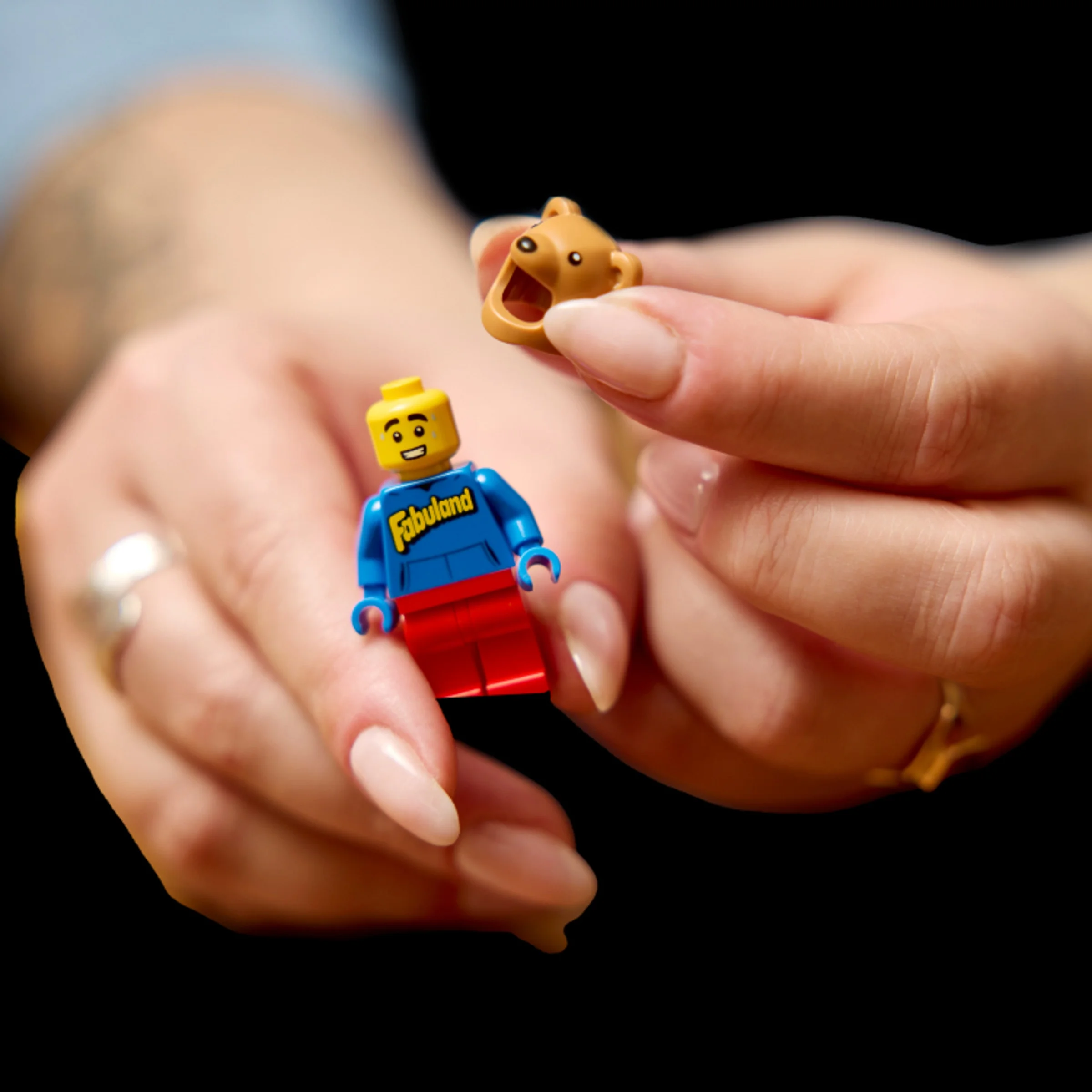 O minifigurină Fabuland și o mască de urs, ținute în mână. Detalii ale minifigurinei.