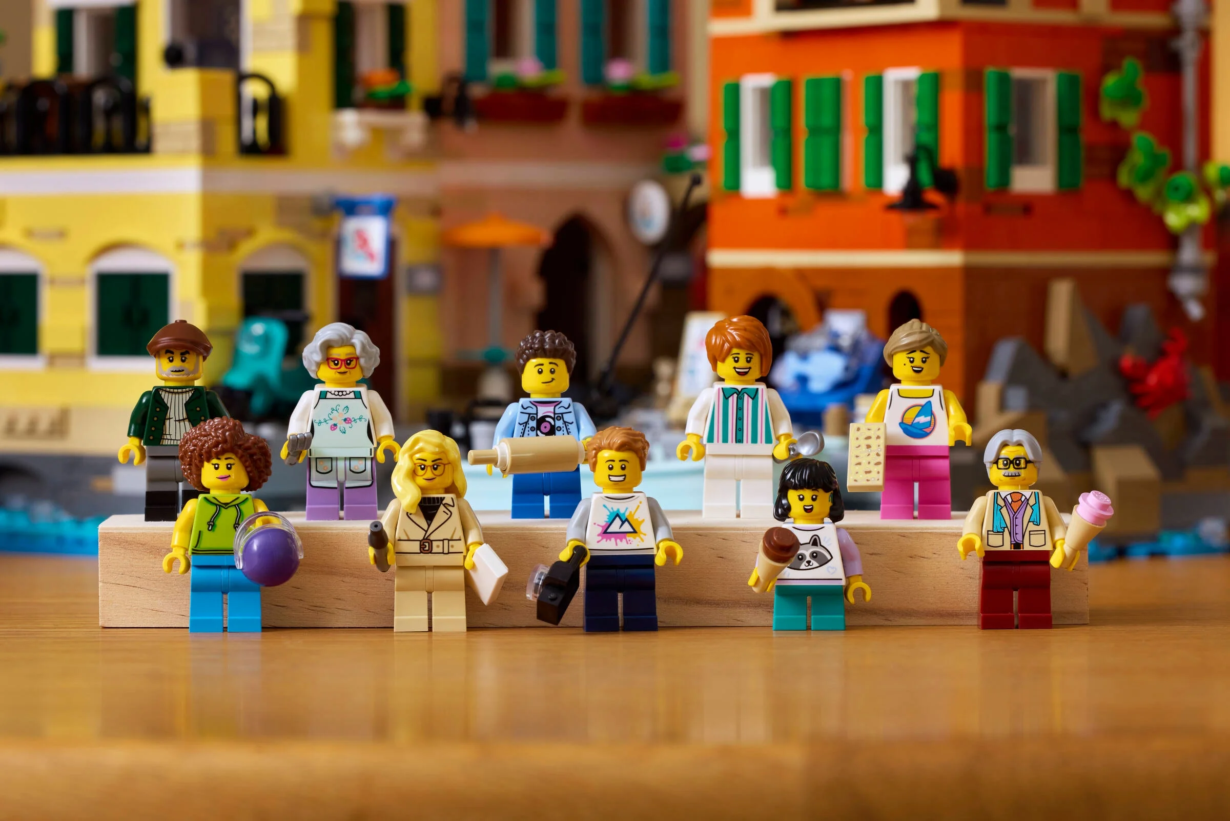 Prezentare detaliată a minifigurinelor LEGO cu fundalul Rivierei Italiene, viu colorat.