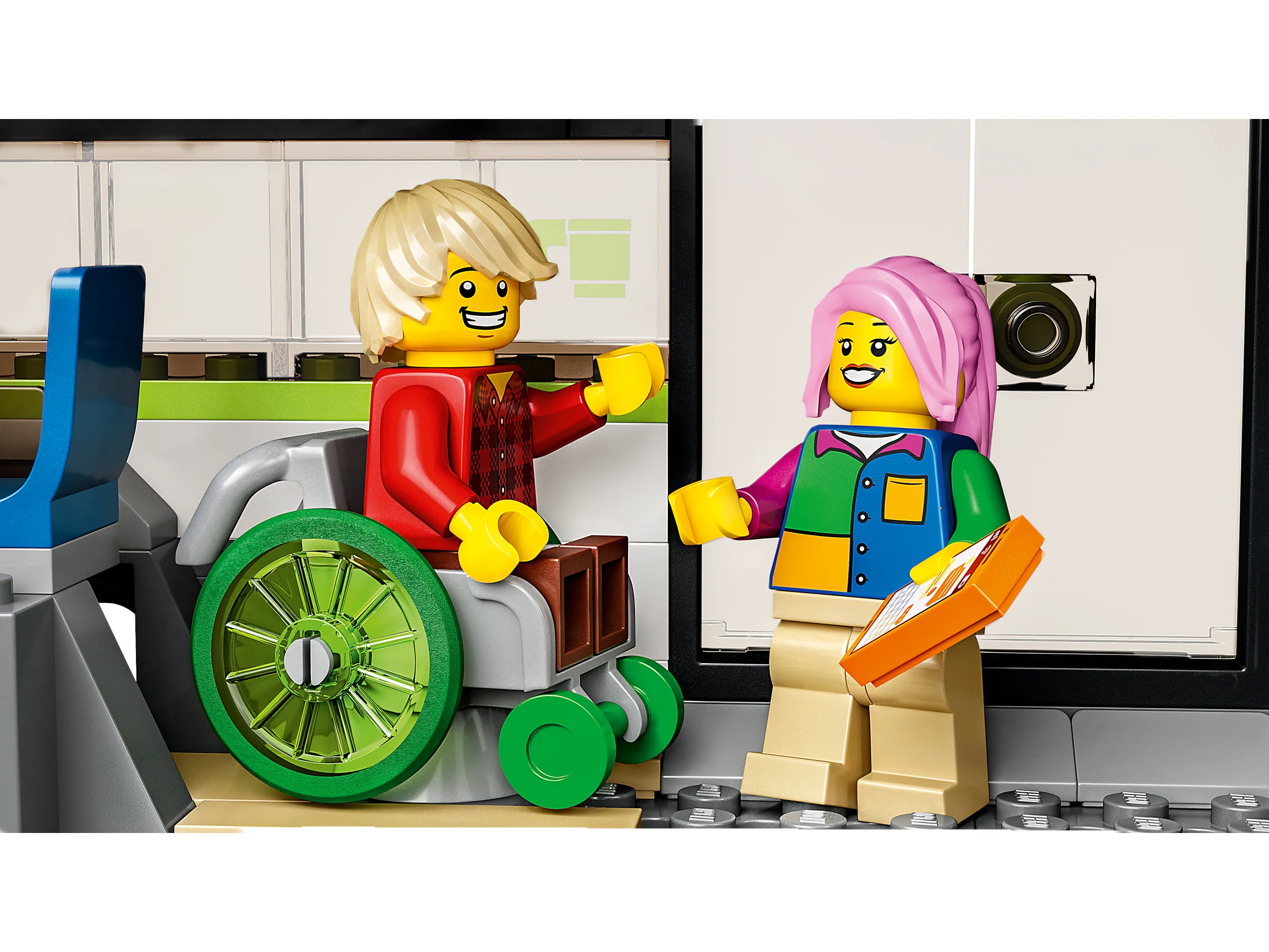 Prim-plan cu două minifigurine: un bărbat în scaun cu rotile și o femeie cu o tabletă.