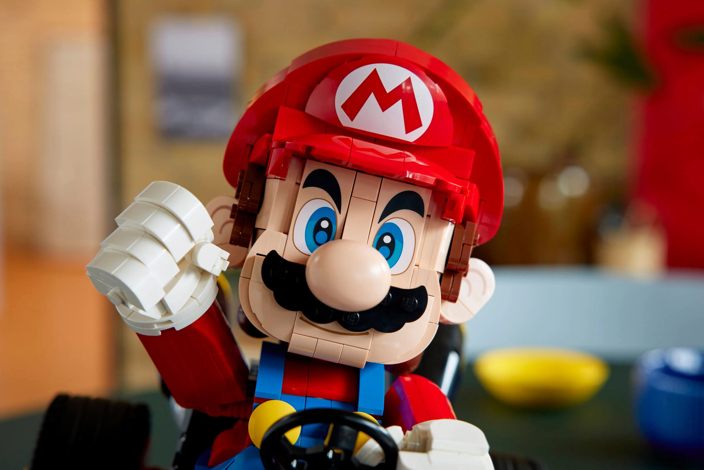 Prim plan al figurii LEGO Mario în kartul său, detaliind construcția și culorile vii.