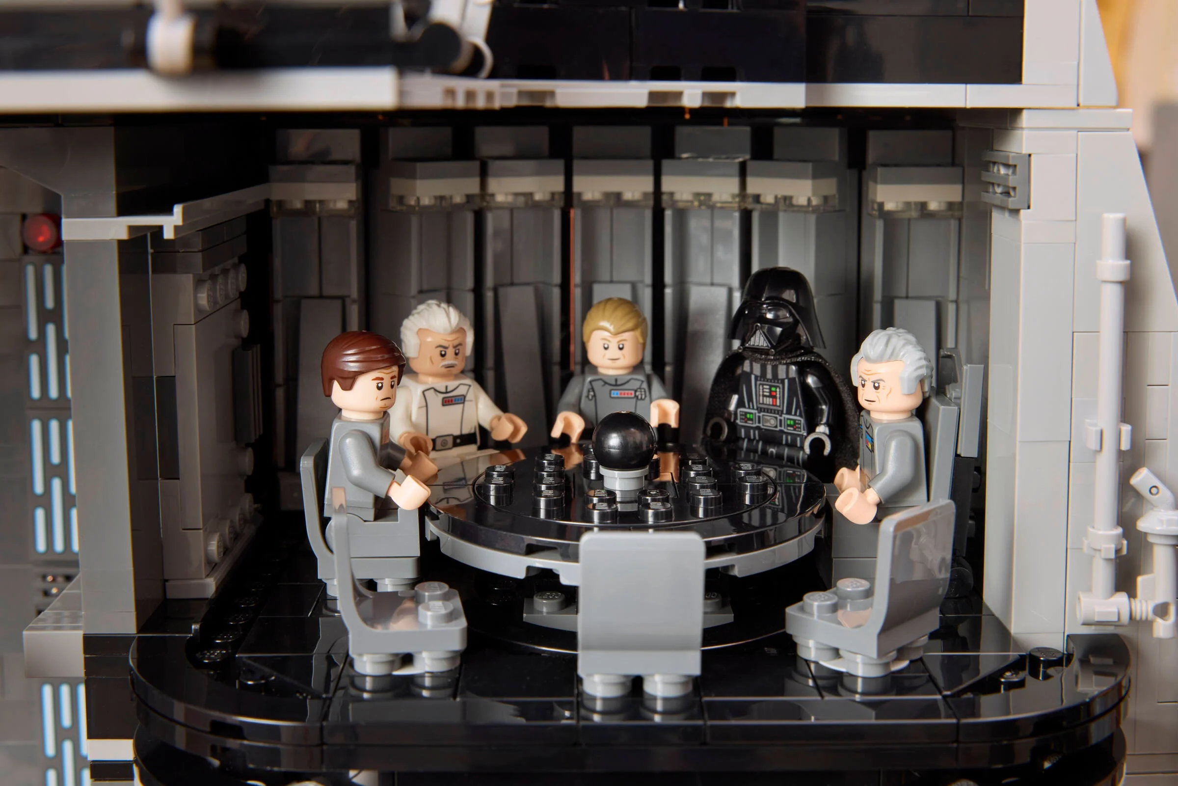 Imagine cu minifigurinele LEGO Darth Vader și ofițeri imperiali la masa de conferințe a Stelei Morții.