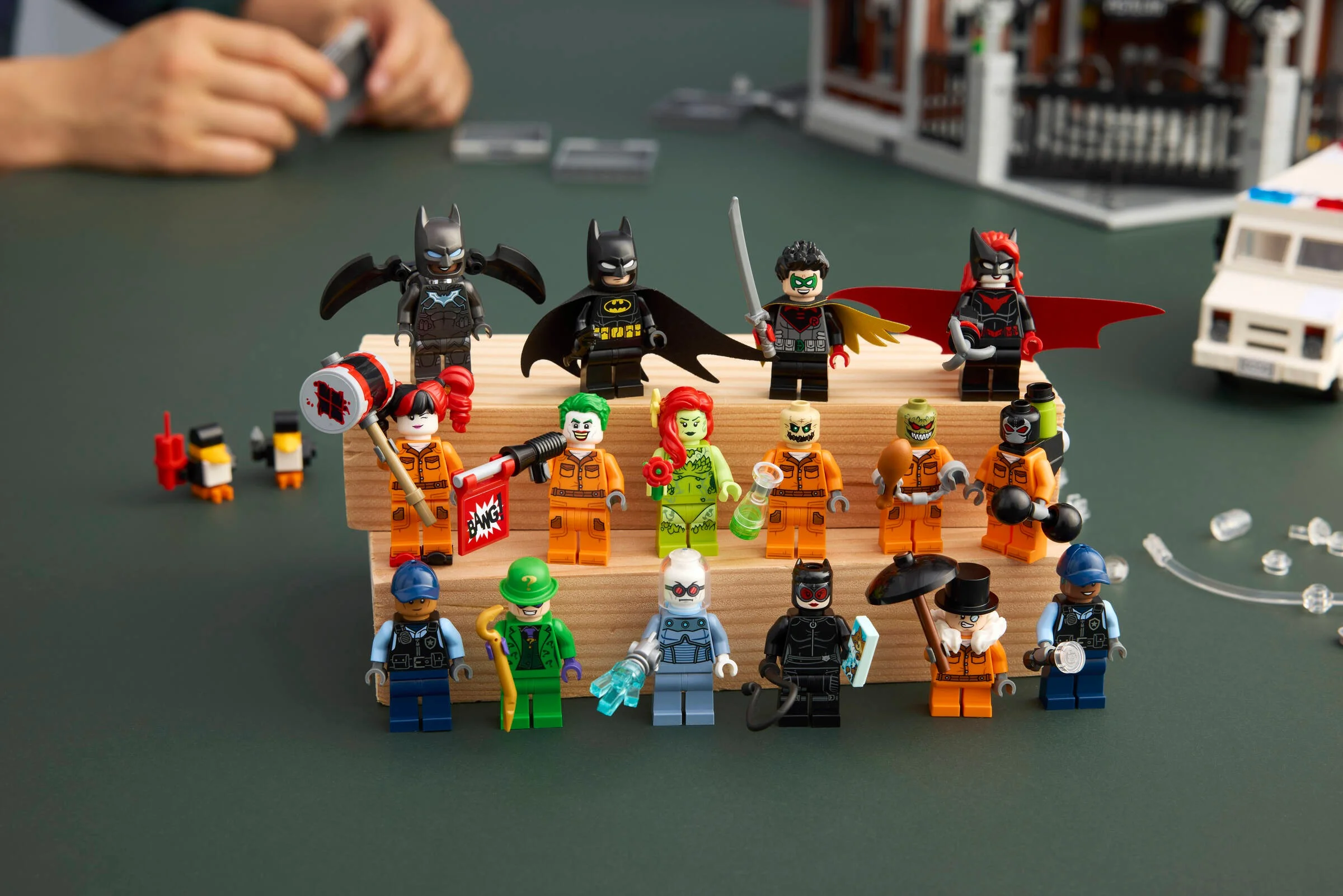 Imagine cu minifigurinele LEGO Arkham Asylum, cu focus pe eroii și răufăcătorii din set.