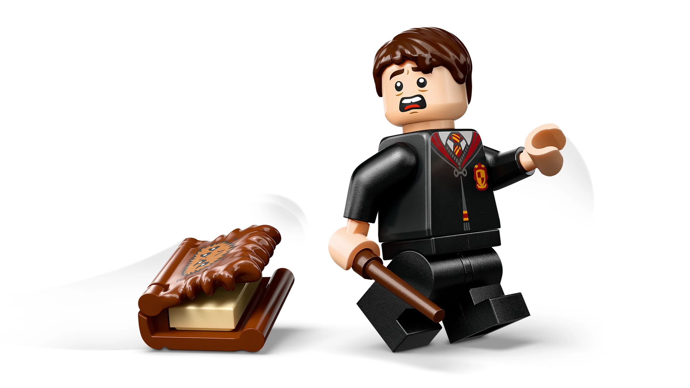 Minifigurina speriată fuge de Cartea Monștrilor, cu bagheta în mână.
