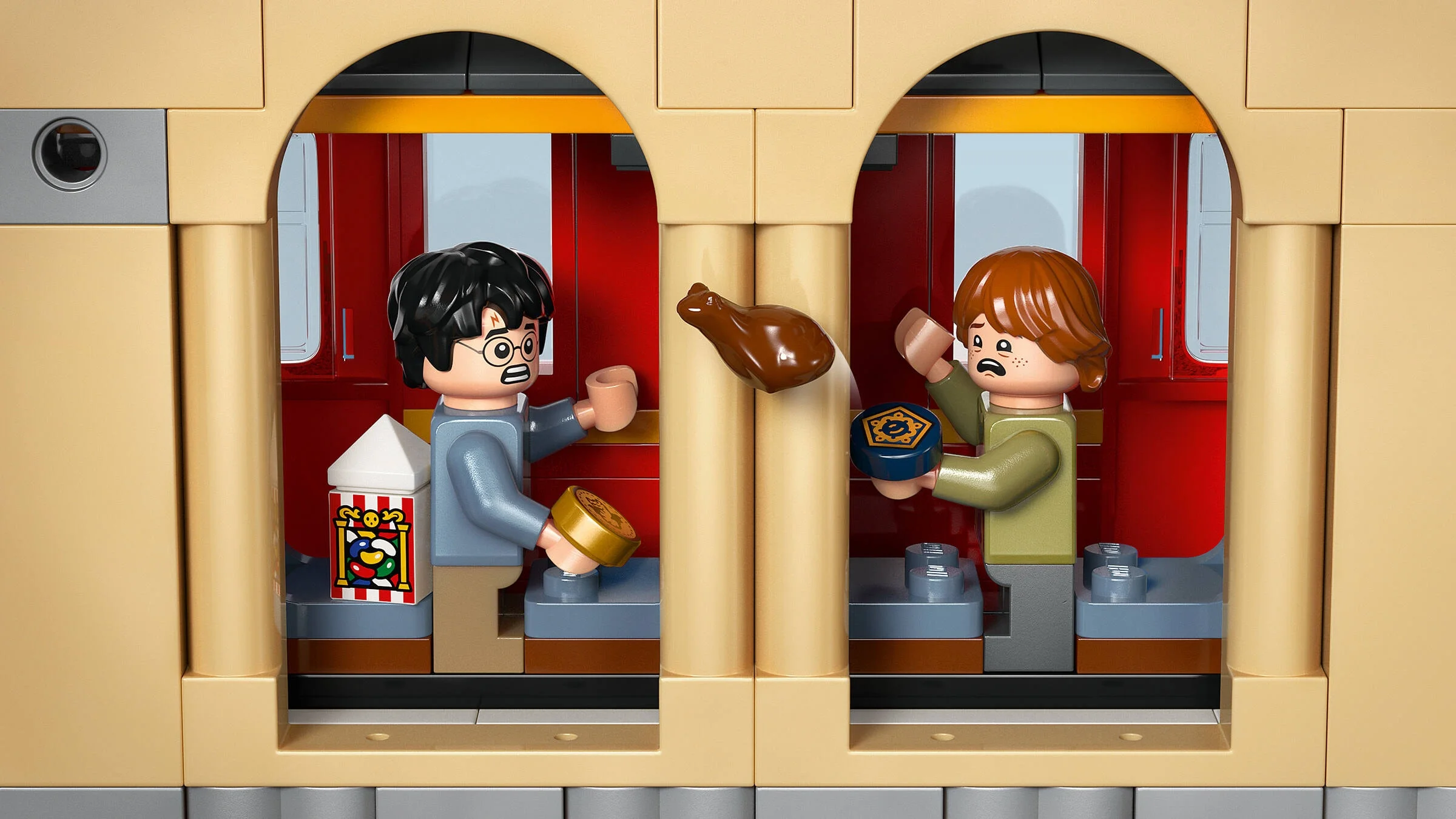 Harry și Ron se bucură de dulciuri și o friptură în compartimentul trenului Hogwarts Express.