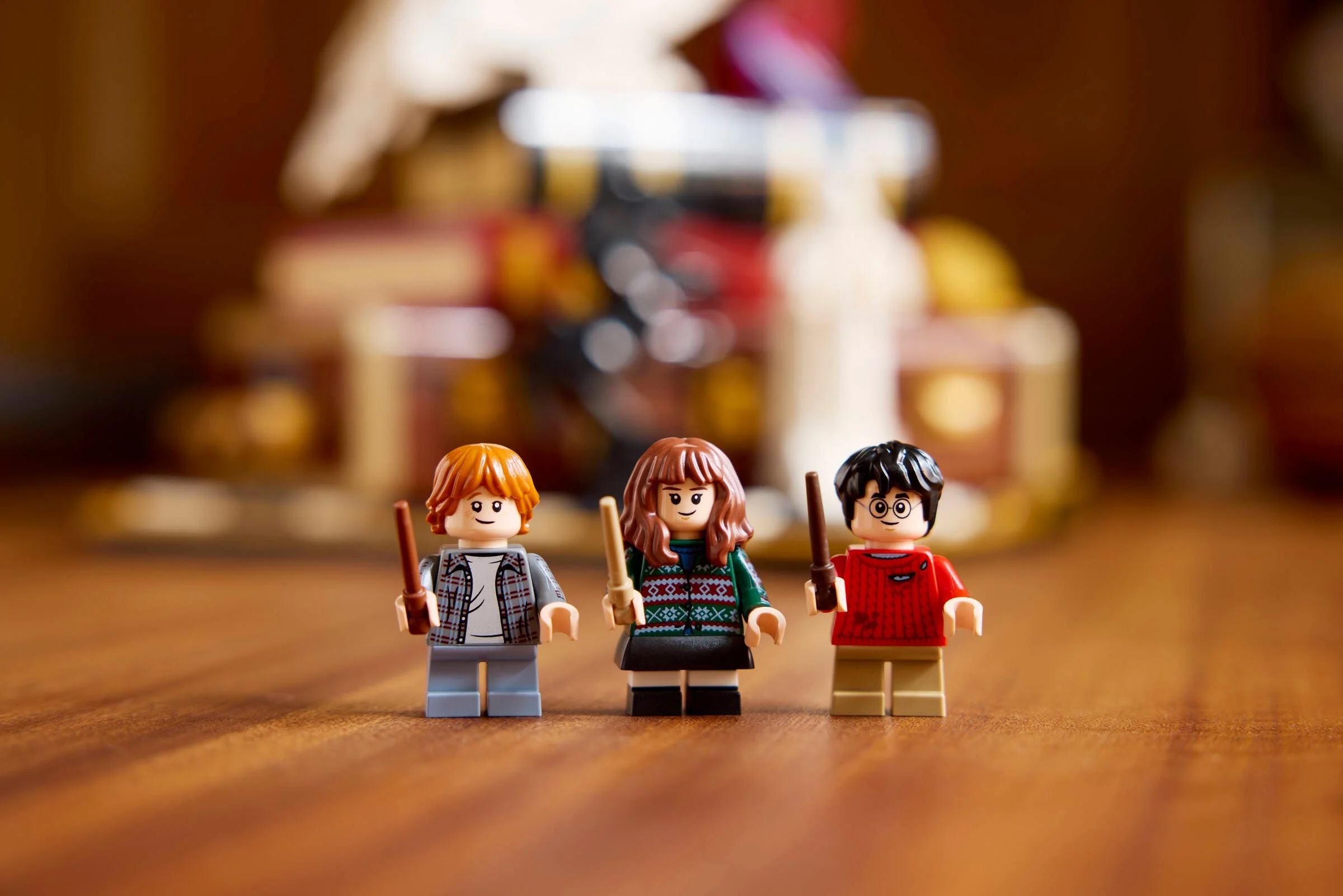 Prim plan cu minifigurinele Harry Potter, Ron Weasley și Hermione Granger.