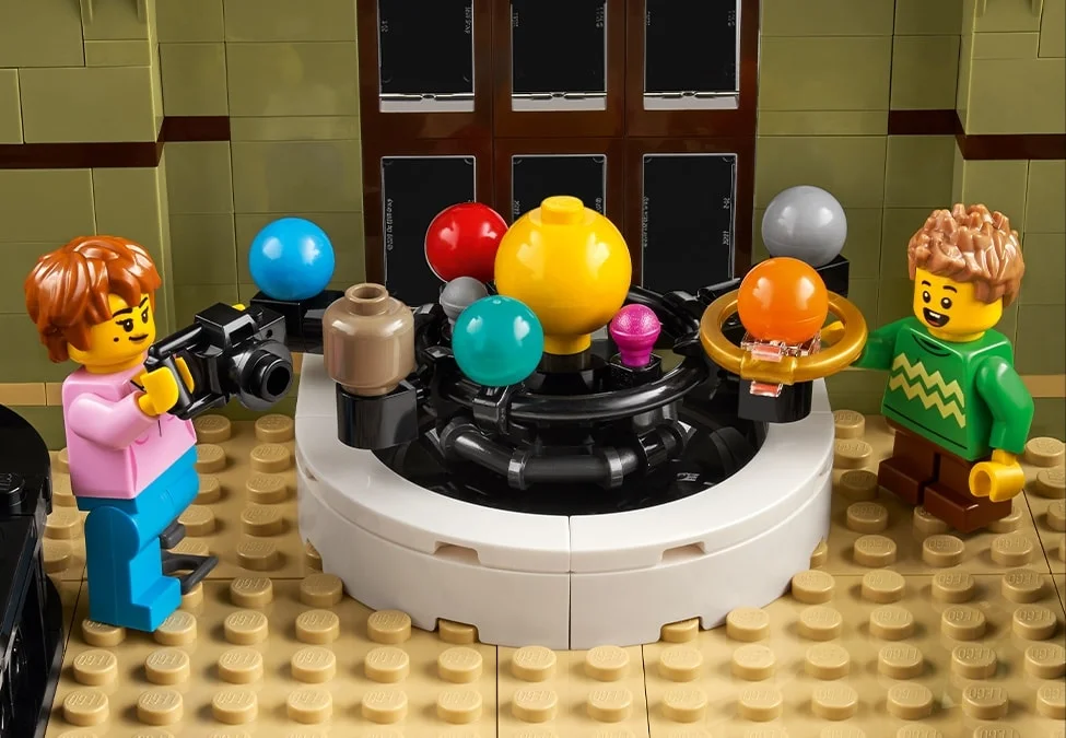 O scenă detaliată cu un planetariu LEGO și minifigurine interacționând, plină de culoare și detalii.