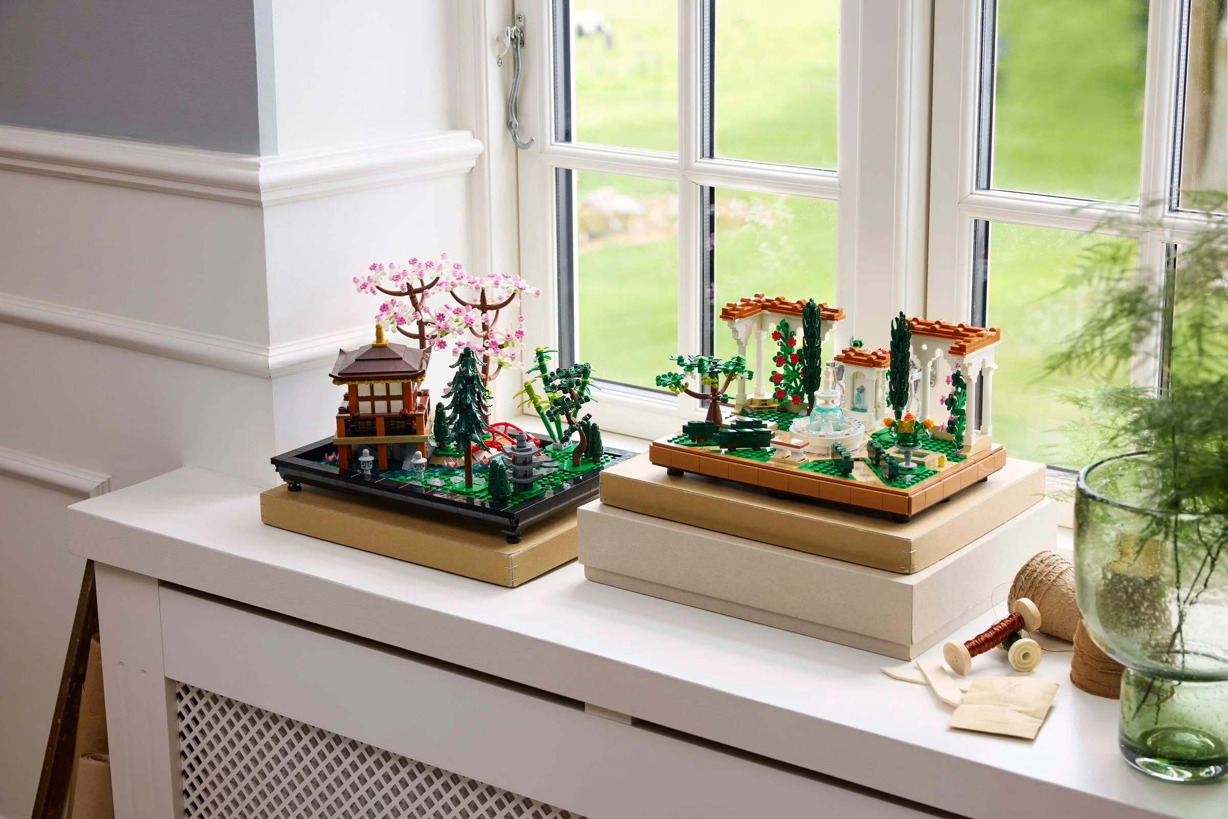 Setul LEGO 10359 Grădina cu Fântână expusă pe o fereastră luminoasă, cu detalii minunate.