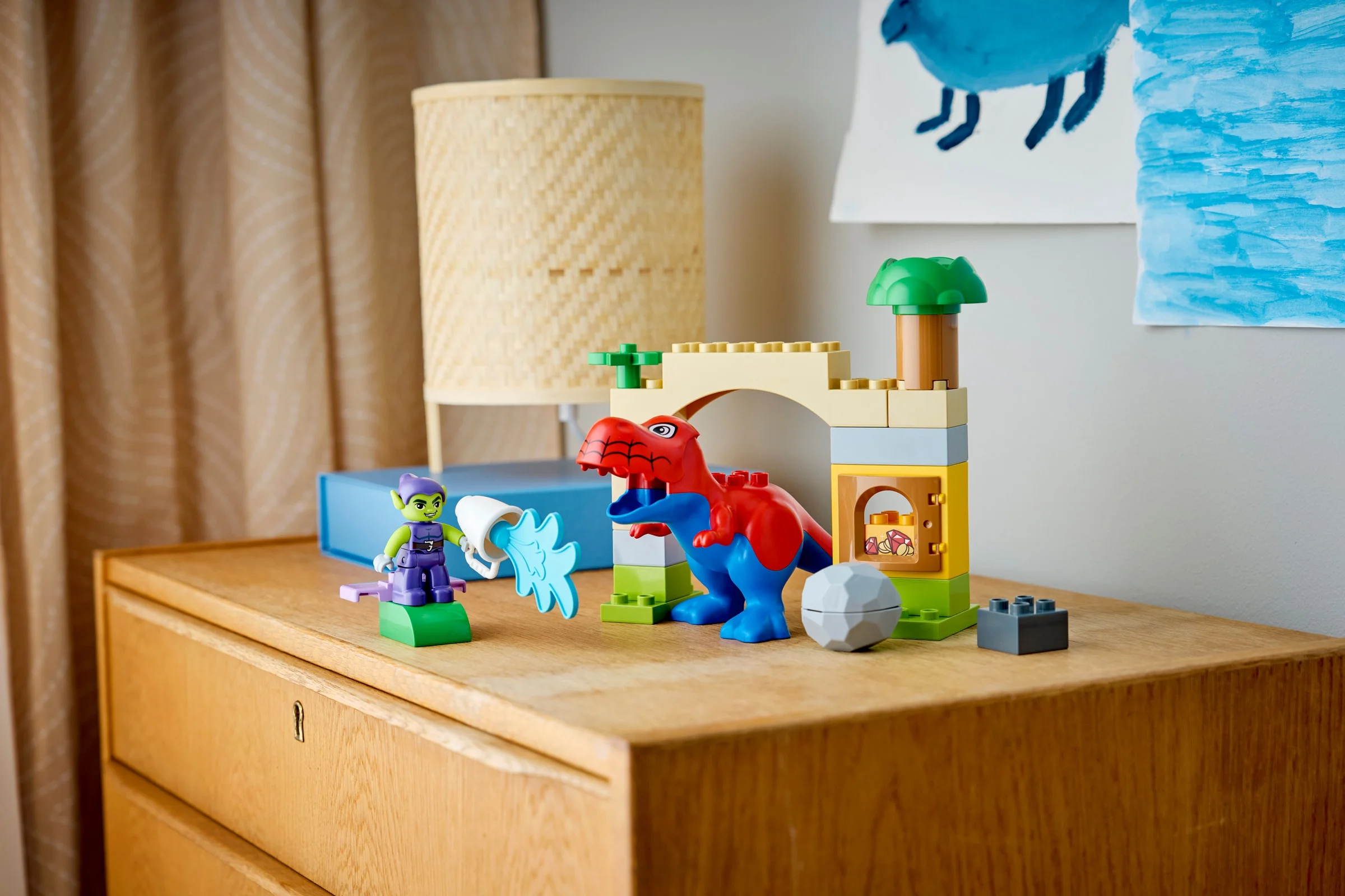 Spidey-Rex și Green Goblin Duplo se confruntă într-o scenă plină de culoare și imaginație.