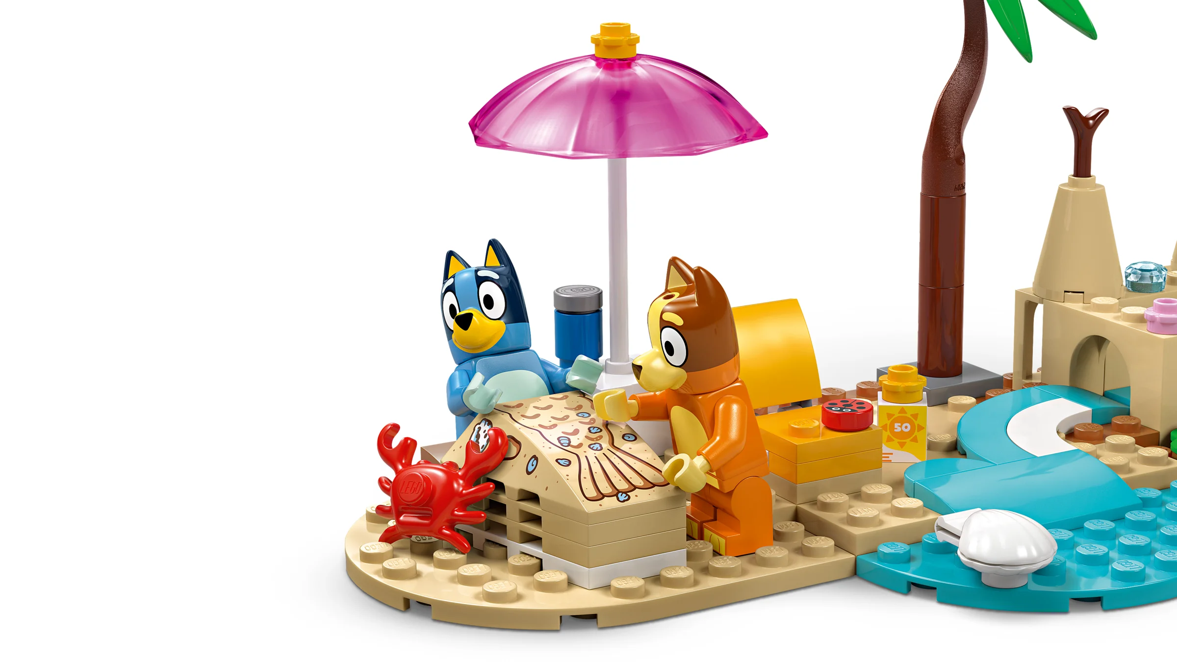 Scenă detaliată cu Bluey și Bingo pe plajă, cu umbrelă, crab și nisip.