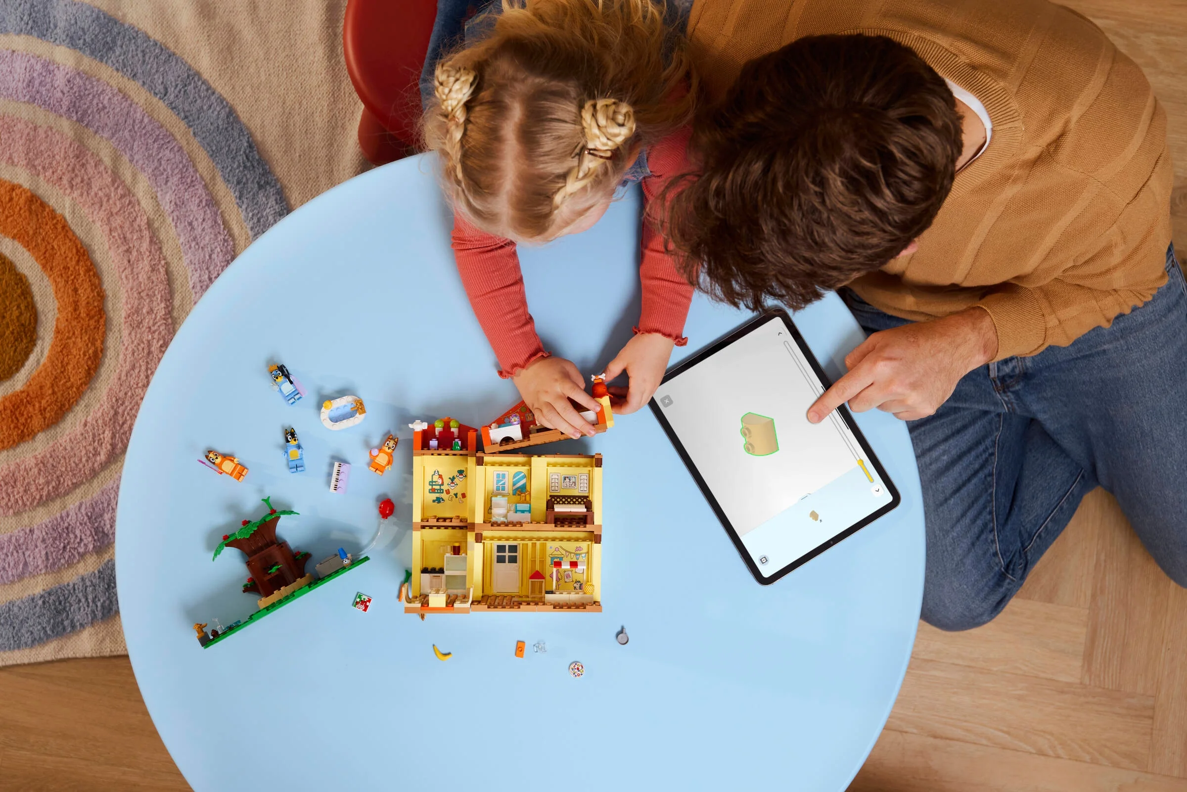 Construind casa Bluey cu ajutorul instrucțiunilor digitale de pe tabletă. Distracție în familie!