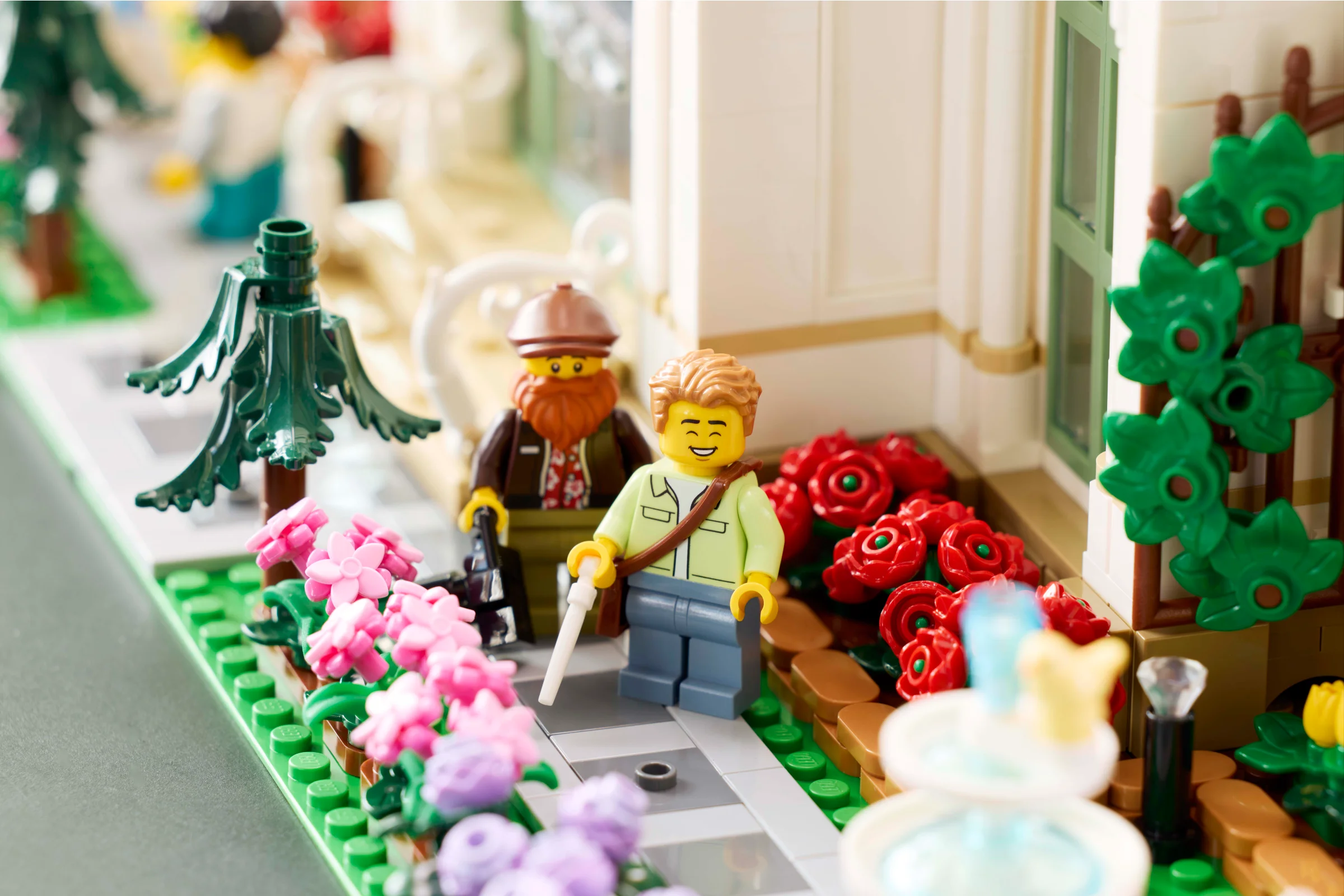 Mini-figurine LEGO vizitând grădina botanică, cu flori diverse și detalii arhitecturale.
