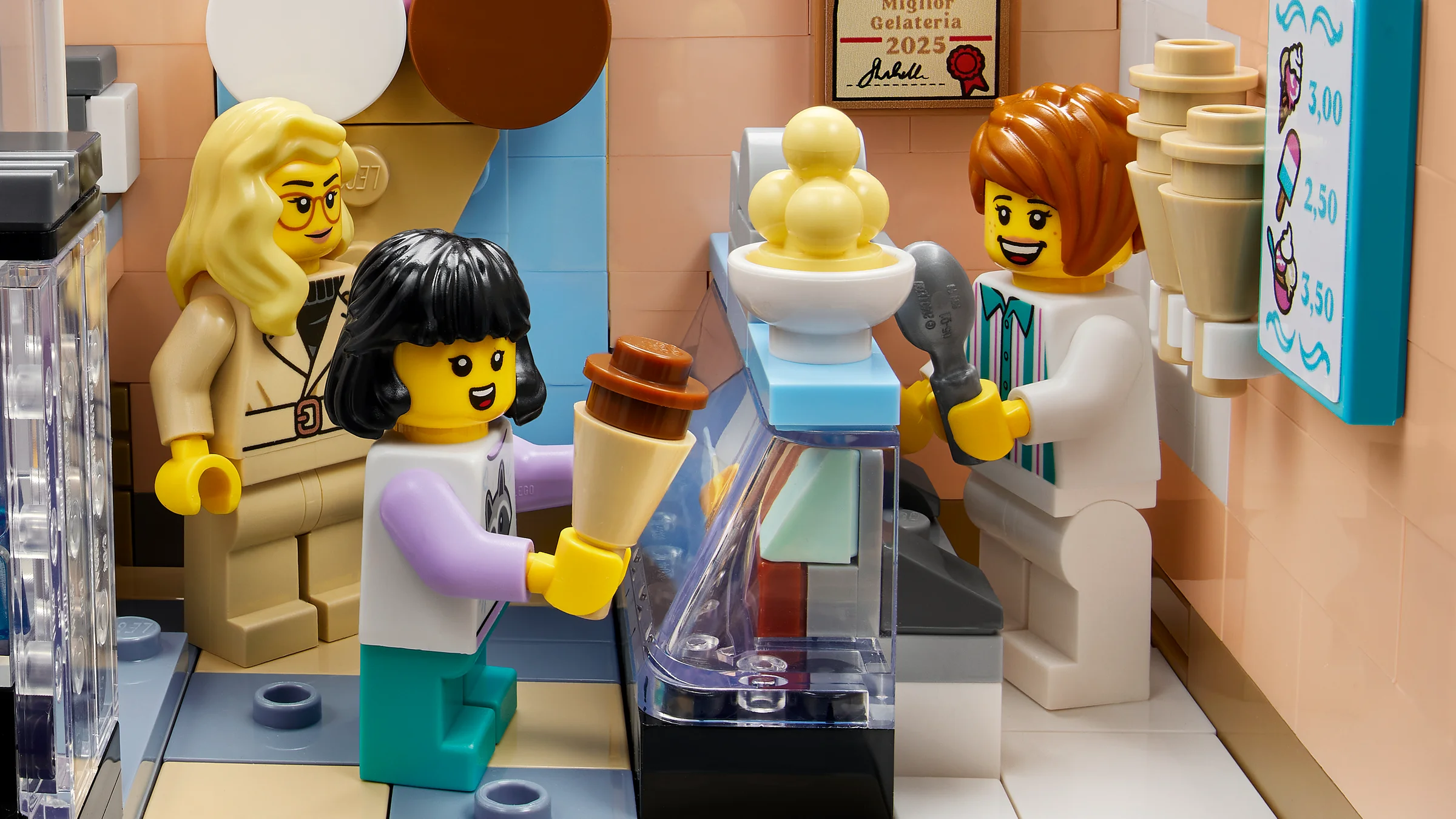 Interiorul gelateriei cu minifigurine LEGO: vânzătoare, clientă și o doamnă.