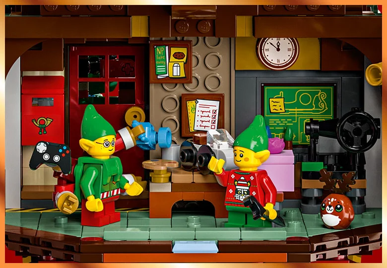 Prim plan cu doi elfi Lego într-un atelier, pregătind decorațiuni de Crăciun. Atmosferă festivă.