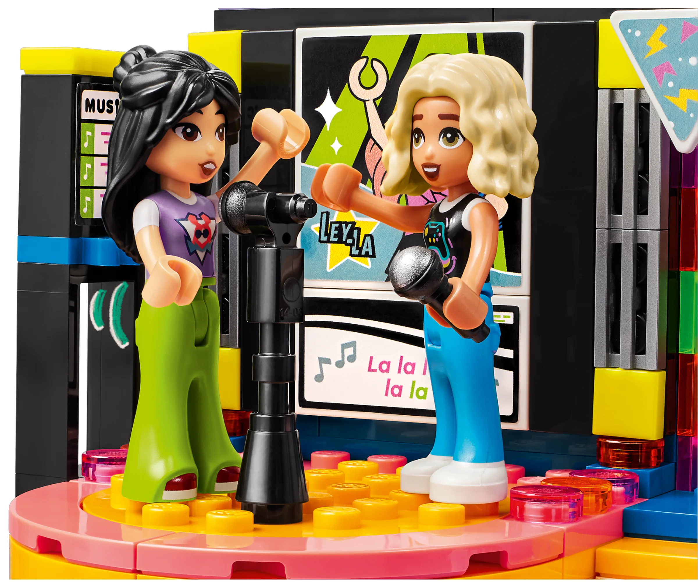 Două minifigurine cântă la karaoke pe o scenă colorată, cu microfoane și ecran. Atmosferă festivă.