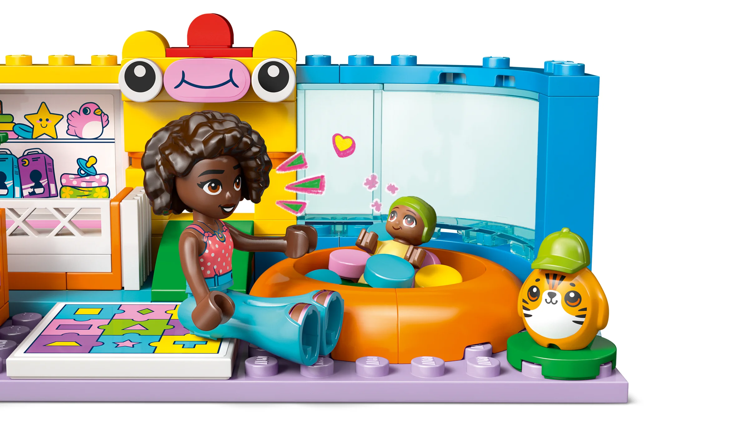Aliya se joacă cu sora ei mai mică într-o cameră plină de jucării LEGO Friends.
