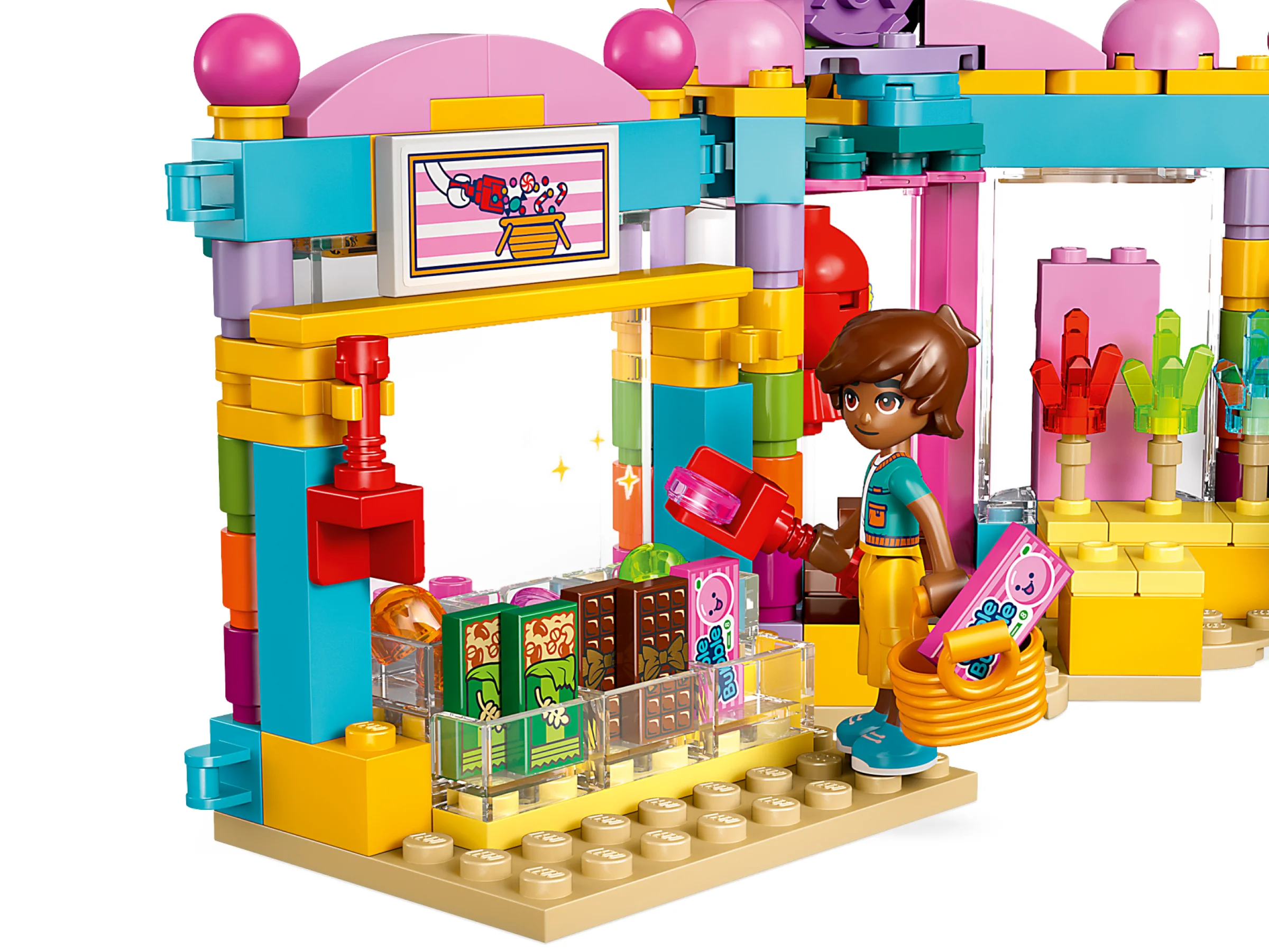 O minifigură alege bomboane dintr-un magazin colorat de dulciuri Heartlake City.