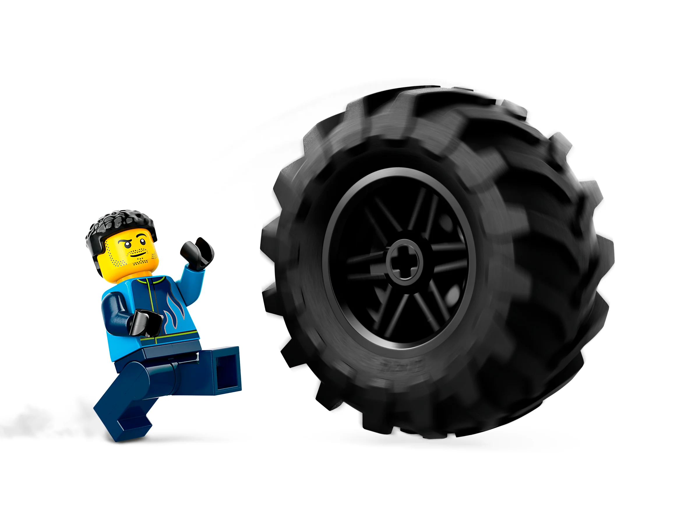 O minifigurină LEGO fuge de roata mare a monster truck-ului, accent pe mărimea roții.