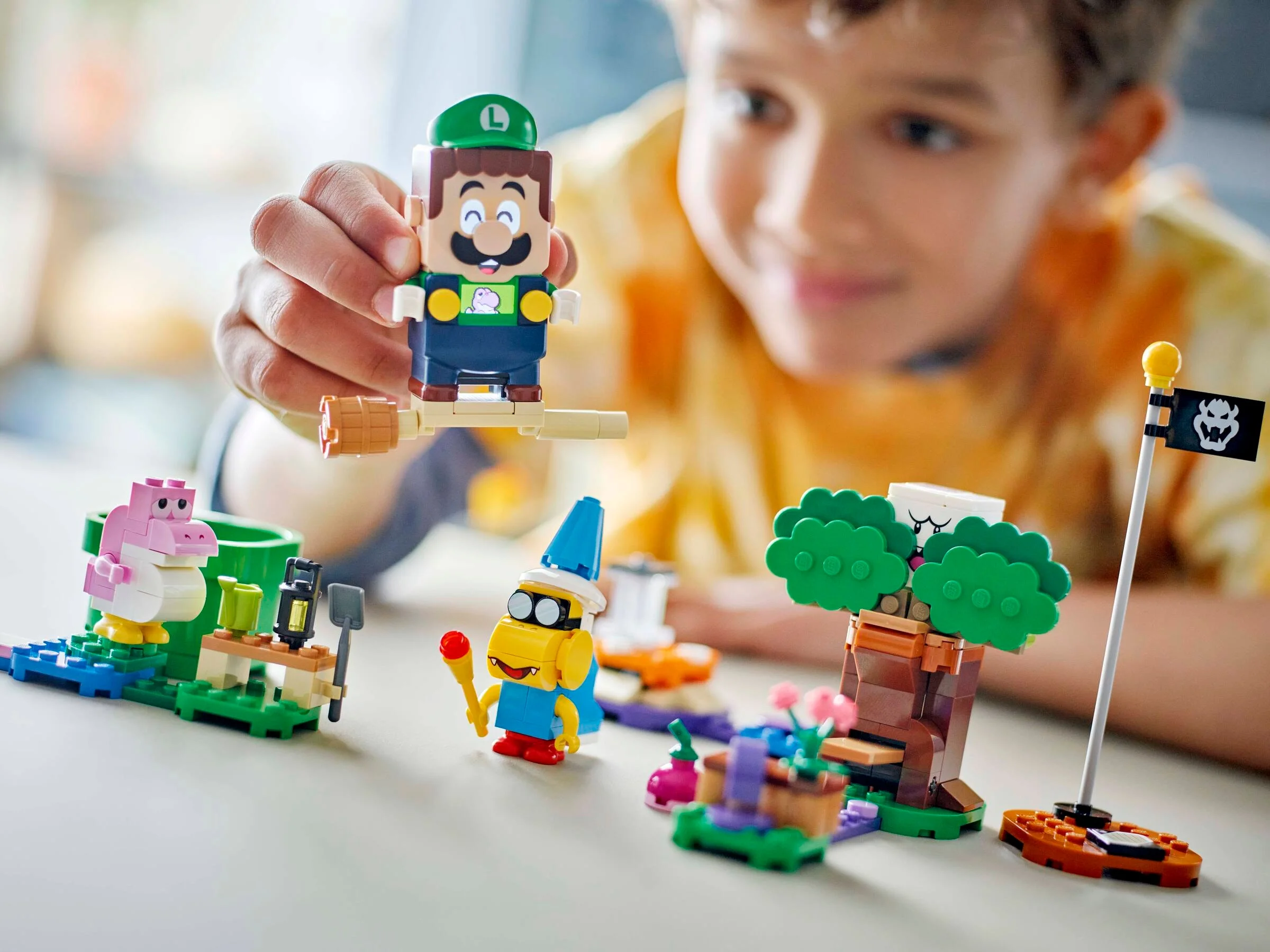 Copil se joacă cu setul LEGO Luigi. Acesta include figurine interactive și decoruri colorate.