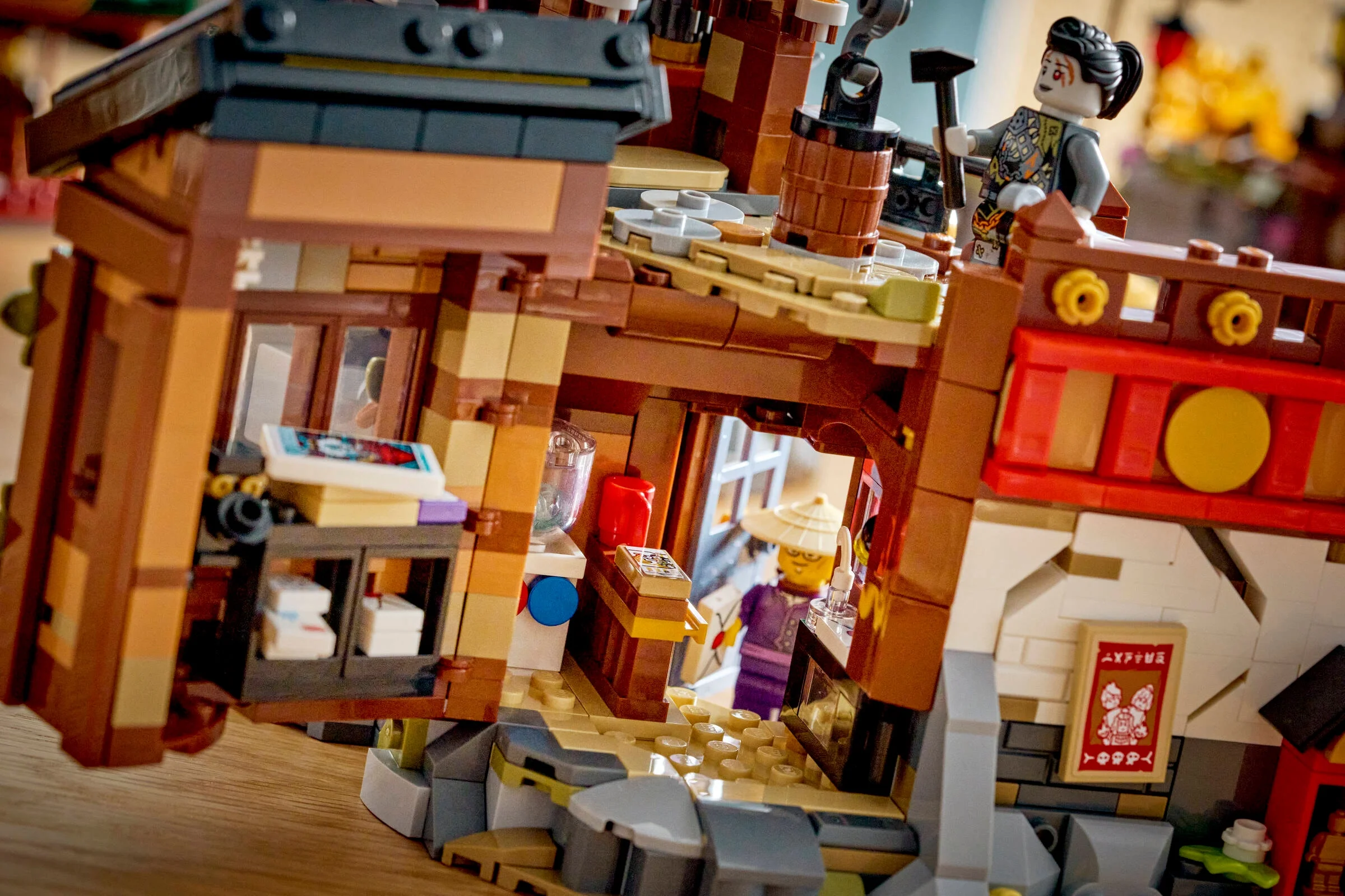Imagine detaliată cu secțiuni din orașul vechi Ninjago, arătând interiorul clădirilor și minifigurine.