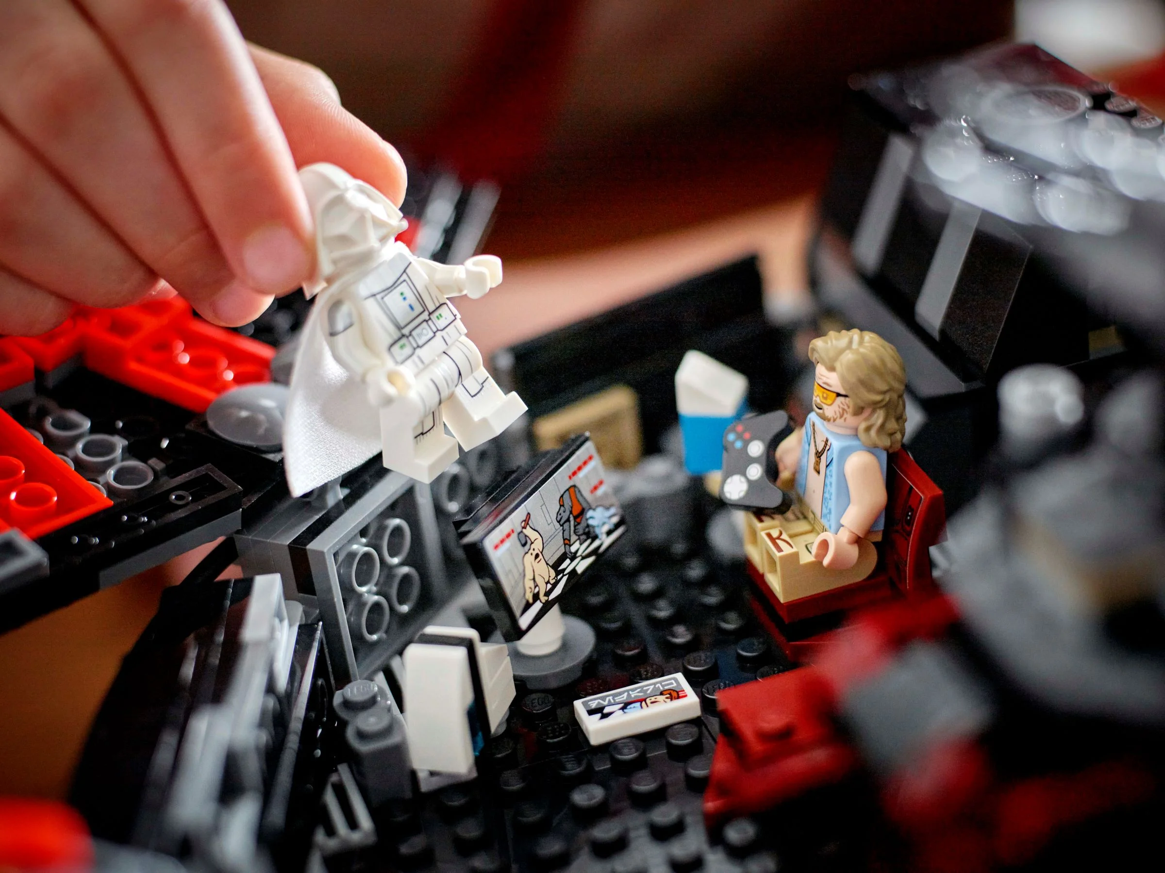 Mână așează figurina Darth Vader alb în nava Dark Falcon, cu detalii LEGO.