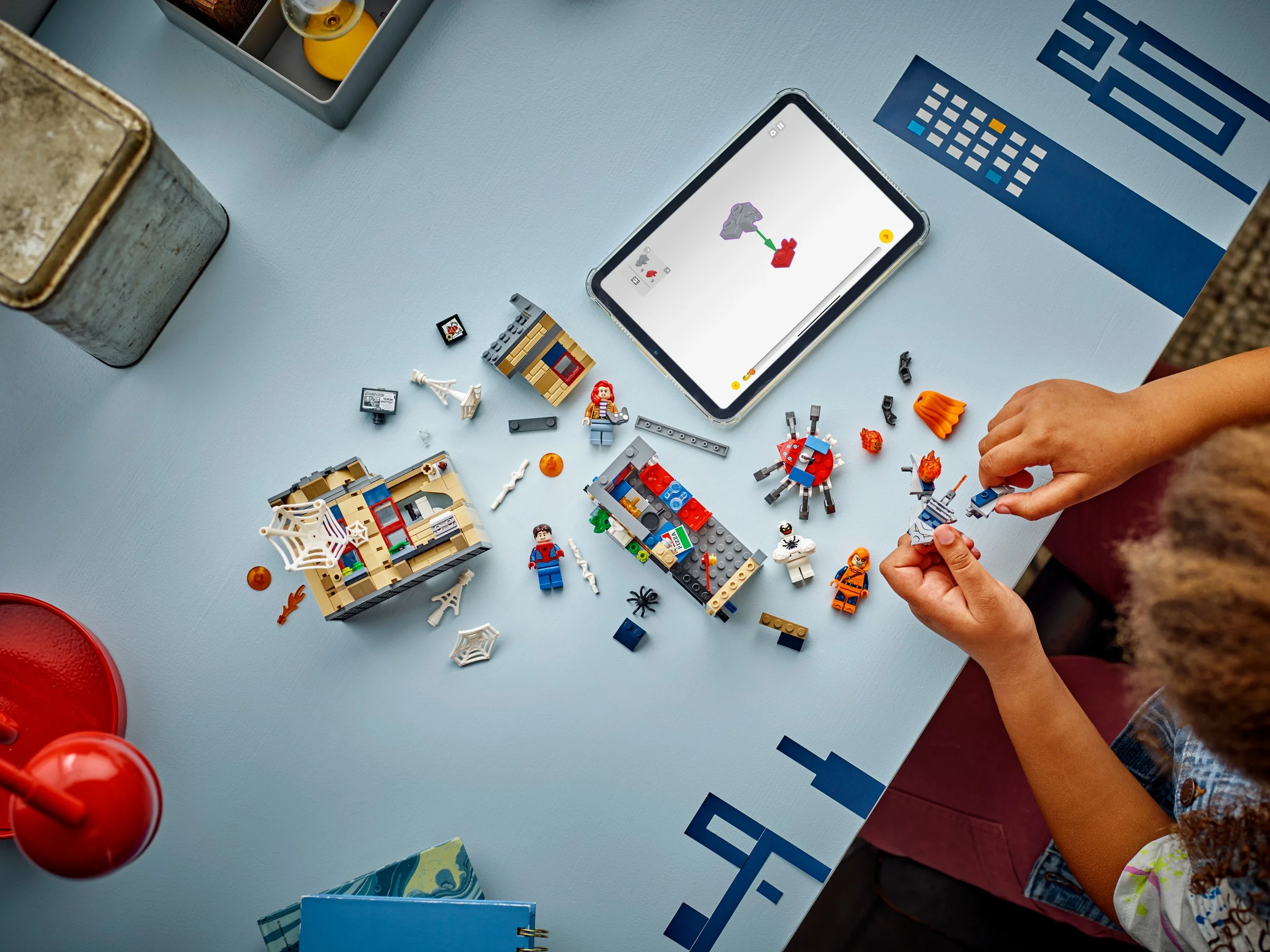 Construirea apartamentului lui Peter Parker cu instrucțiuni digitale. Elemente împrăștiate pe masă.