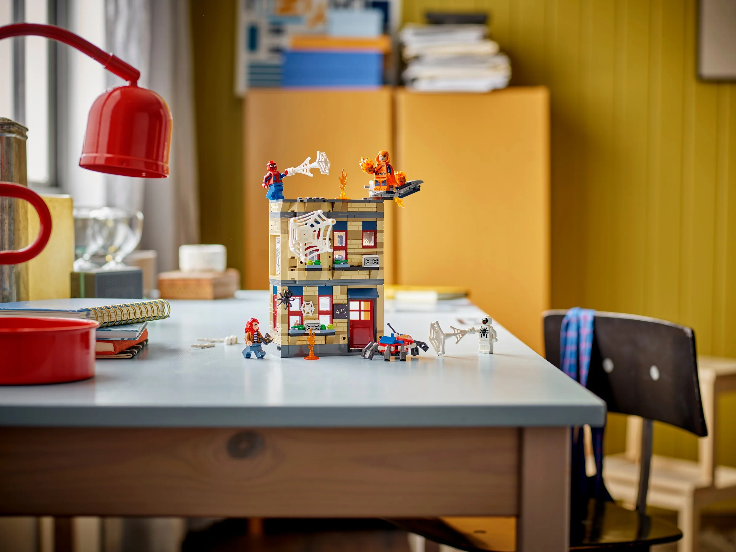 Setul LEGO 76317 prezintă apartamentul lui Peter Parker cu minifigurine și accesorii pe birou.