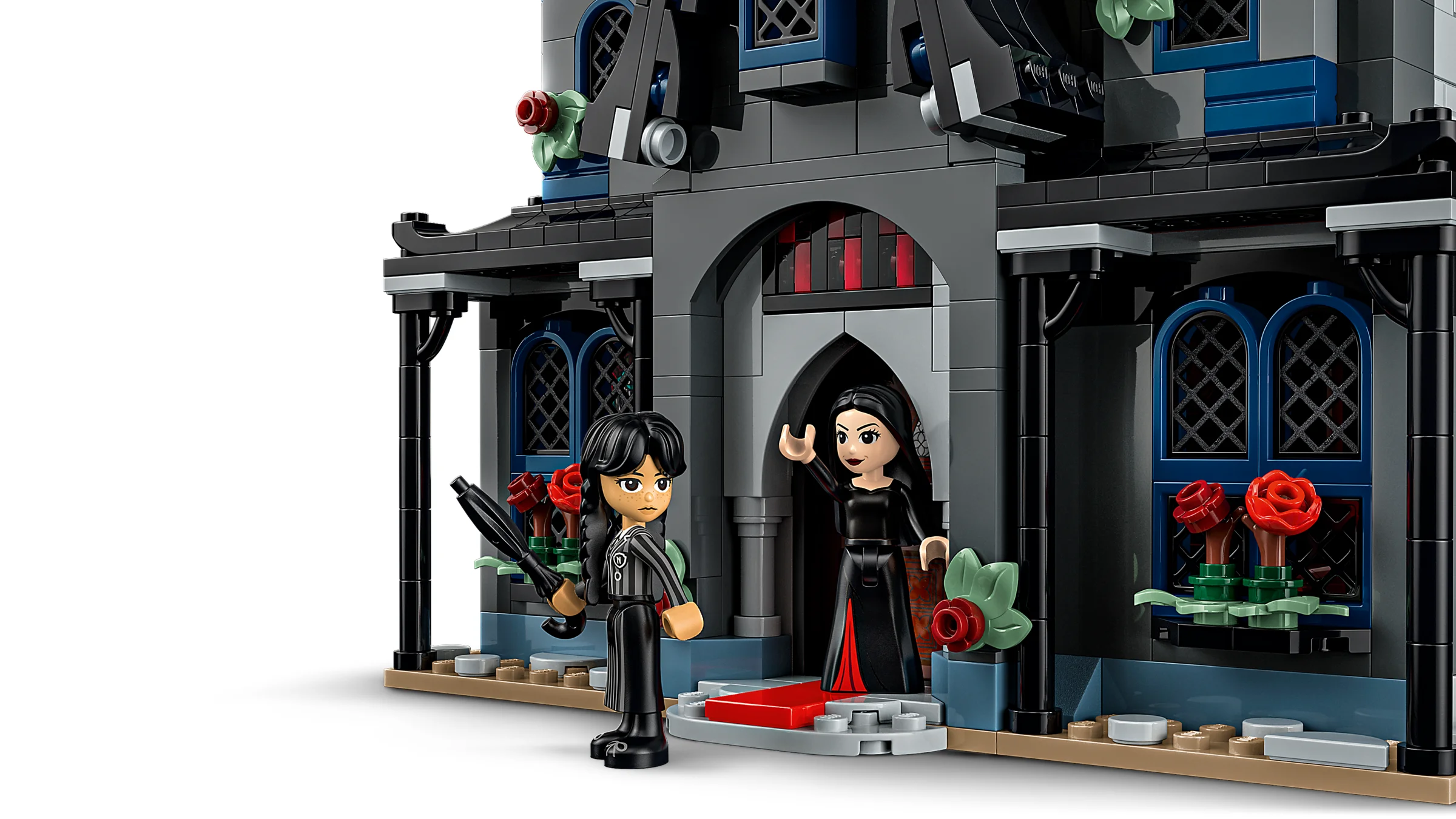 Prim-plan cu Morticia și Wednesday Addams în fața casei lor LEGO. Aspect gotic șarmant.