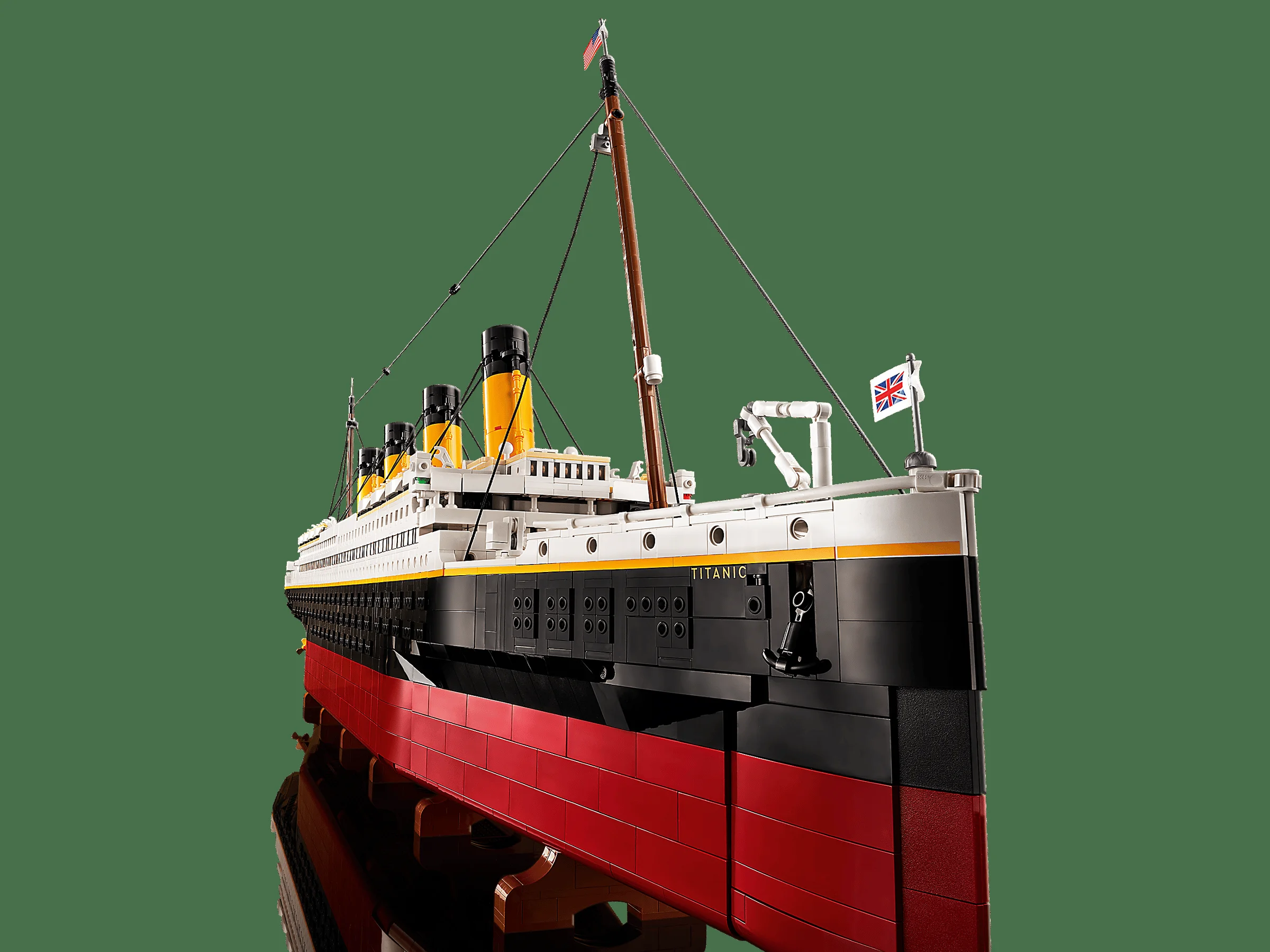 Modelul LEGO Titanic detaliat, cu corp roșu, negru și alb, pe un suport, reflectat pe o suprafață.