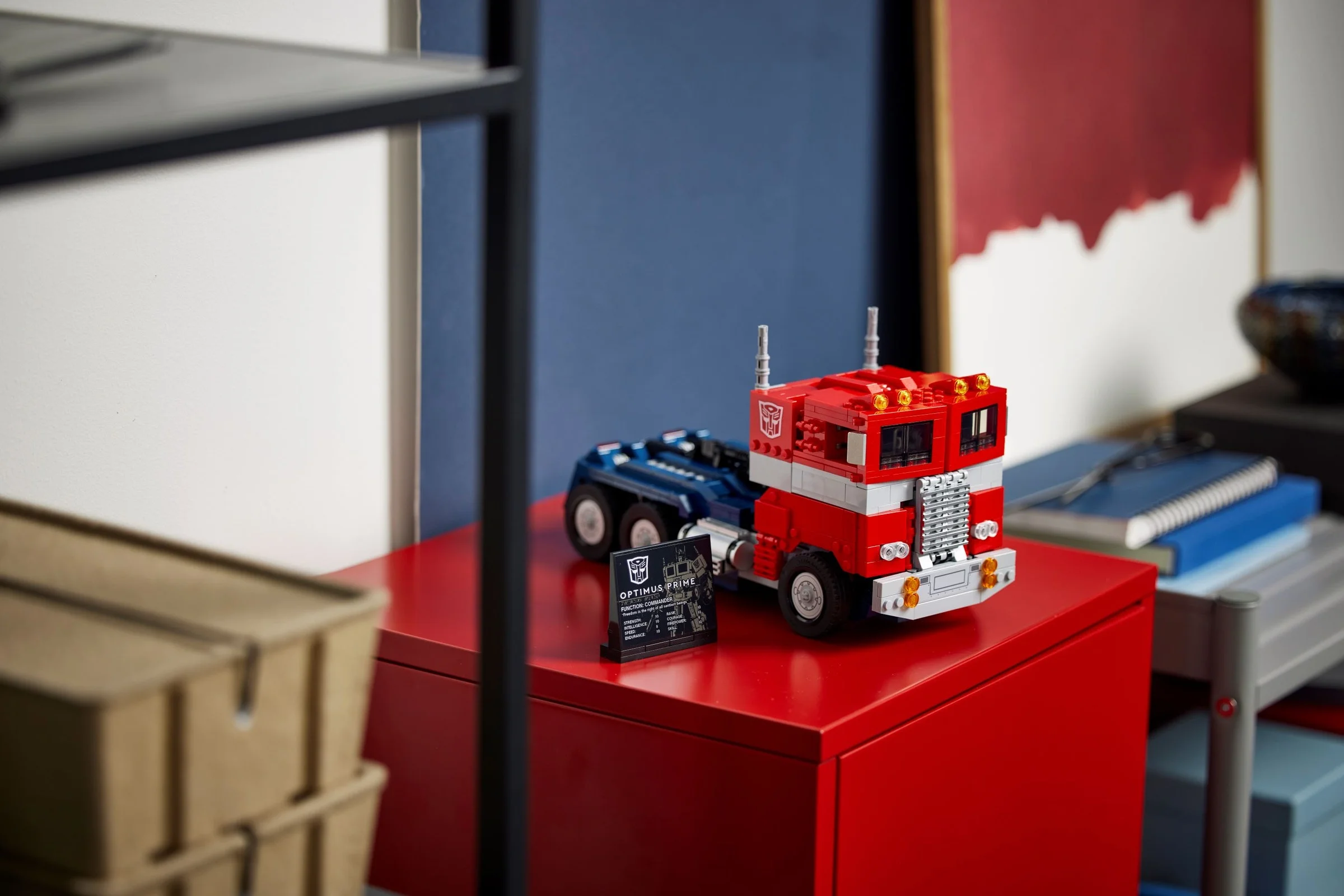 Modelul LEGO Optimus Prime, în formă de camion, expus cu placa informativă. Detaliu rafinat.
